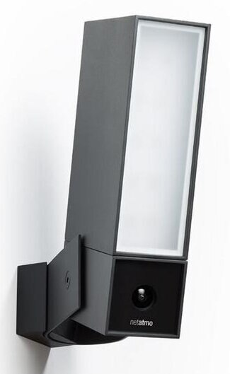 Czarna kamera bezpieczeństwa Netatmo zamontowana na białej ścianie. Ma prostokątny kształt.