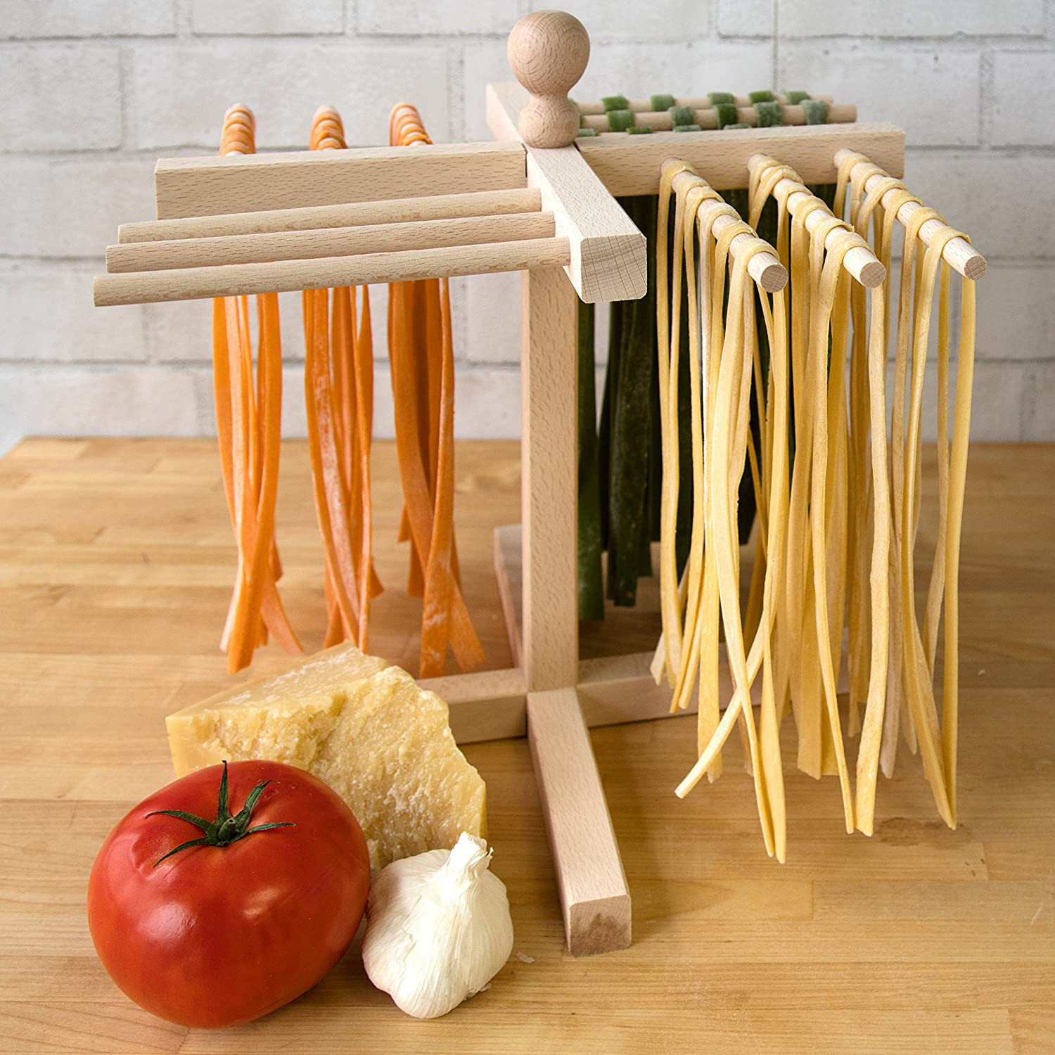 Pasta e ingredienti: stendino per pasta, pomodoro, aglio, formaggio e pasta.