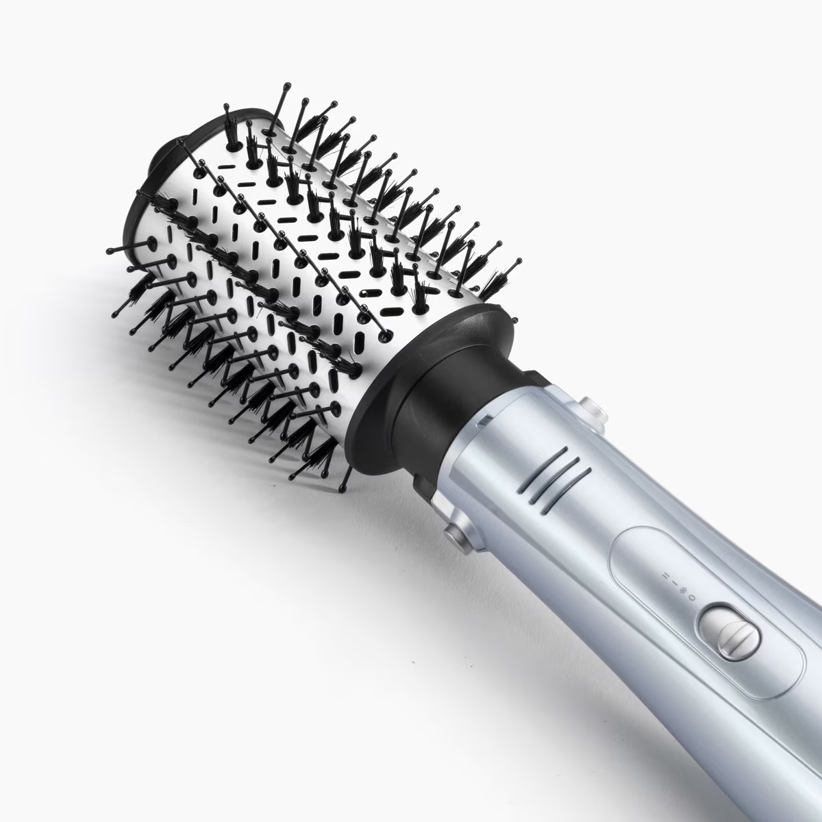 Cepillo para peinar el cabello, plateado y negro. Fondo blanco con vista en ángulo.