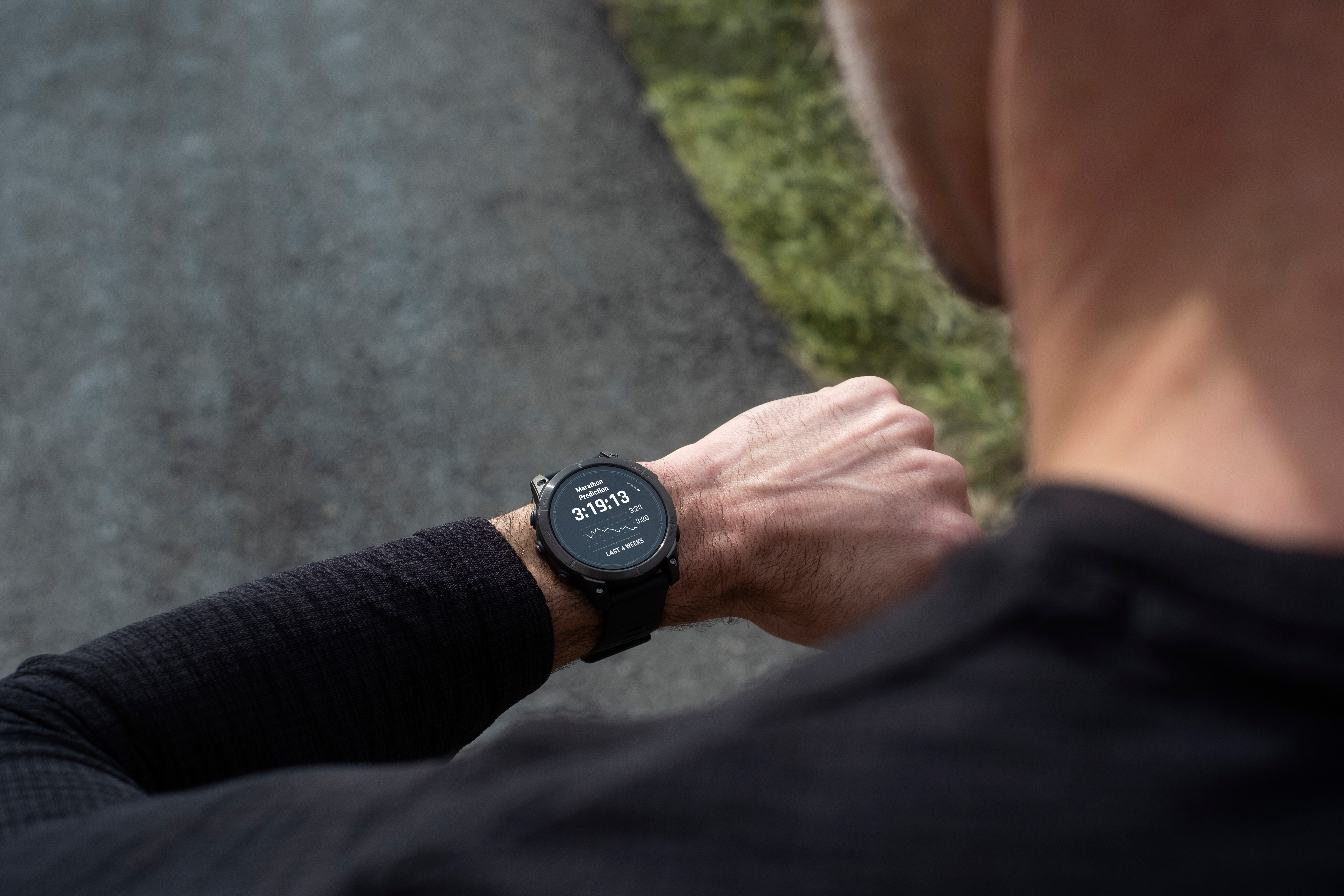 Personne portant une smartwatch, vérifiant l'heure et les statistiques, en extérieur.
