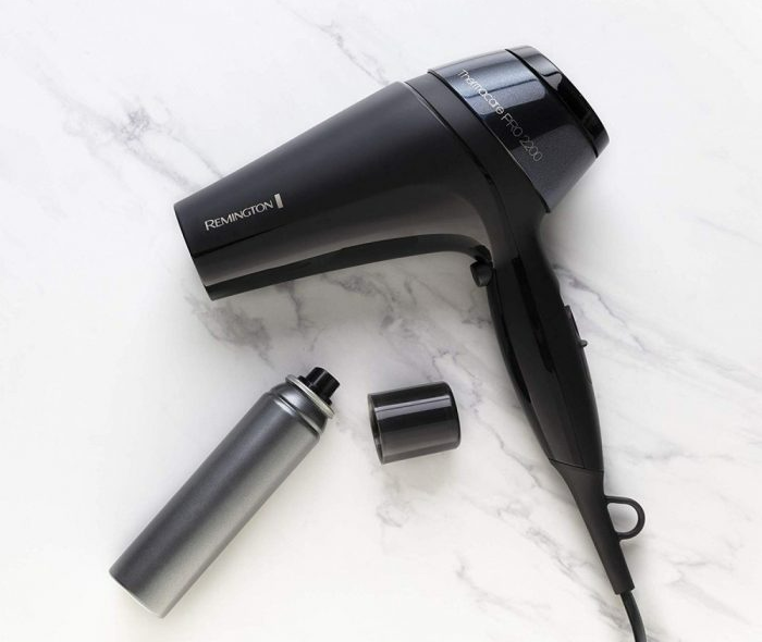 Fekete hajszárító spray palackkal és kupakkal márvány felületen. Remington Thermacare Pro 2200.