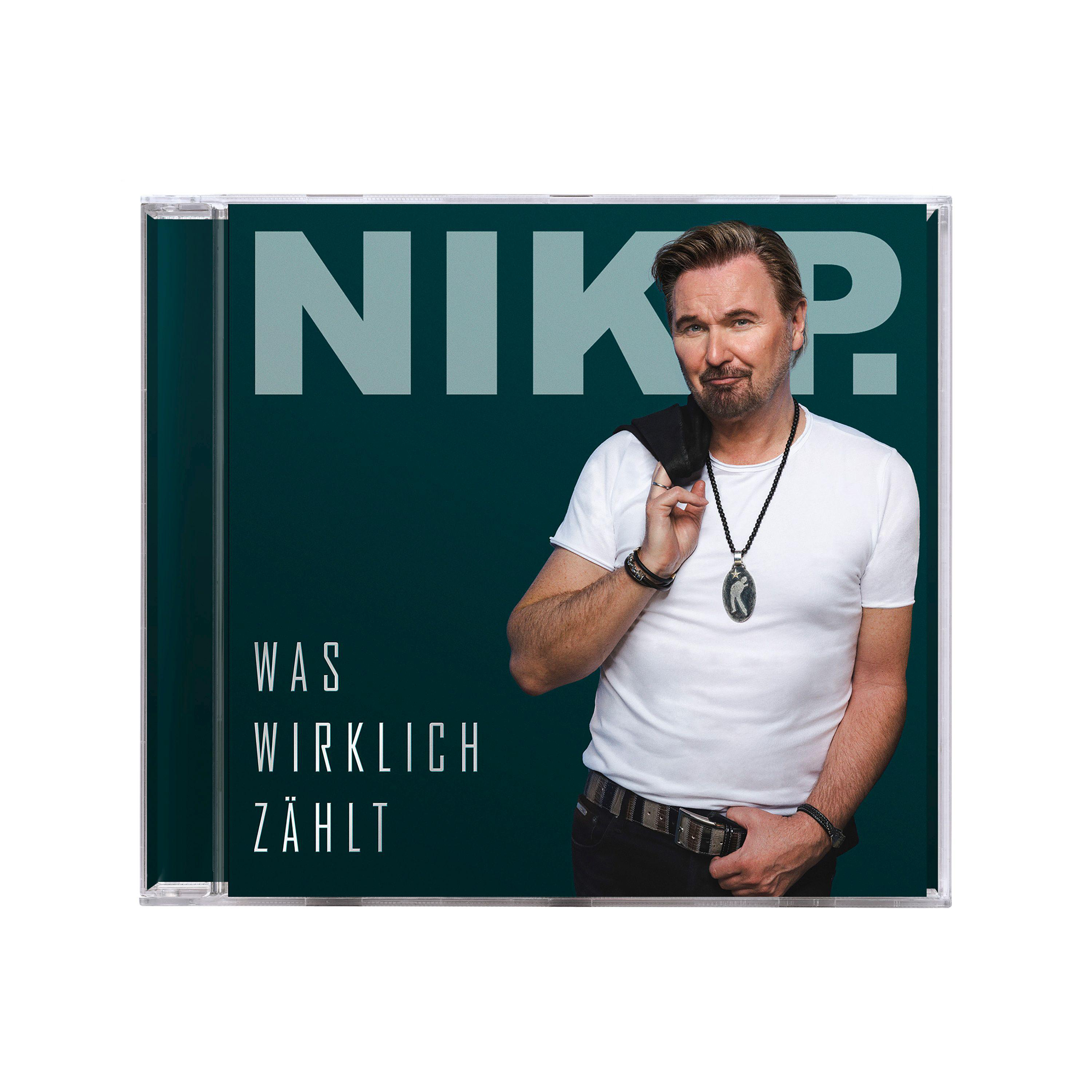CD-Hülle mit einem Mann in einem weißen Hemd und einer schwarzen Jacke. Das Wort 'NIK' steht oben.