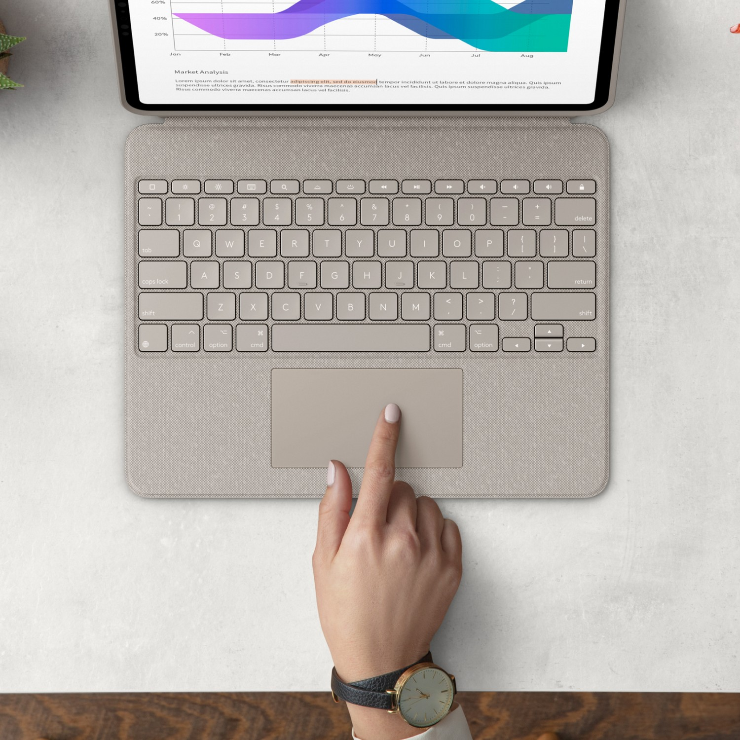 La main d'une personne sur un clavier avec une surface gris clair et un graphique sur l'écran en arrière-plan.