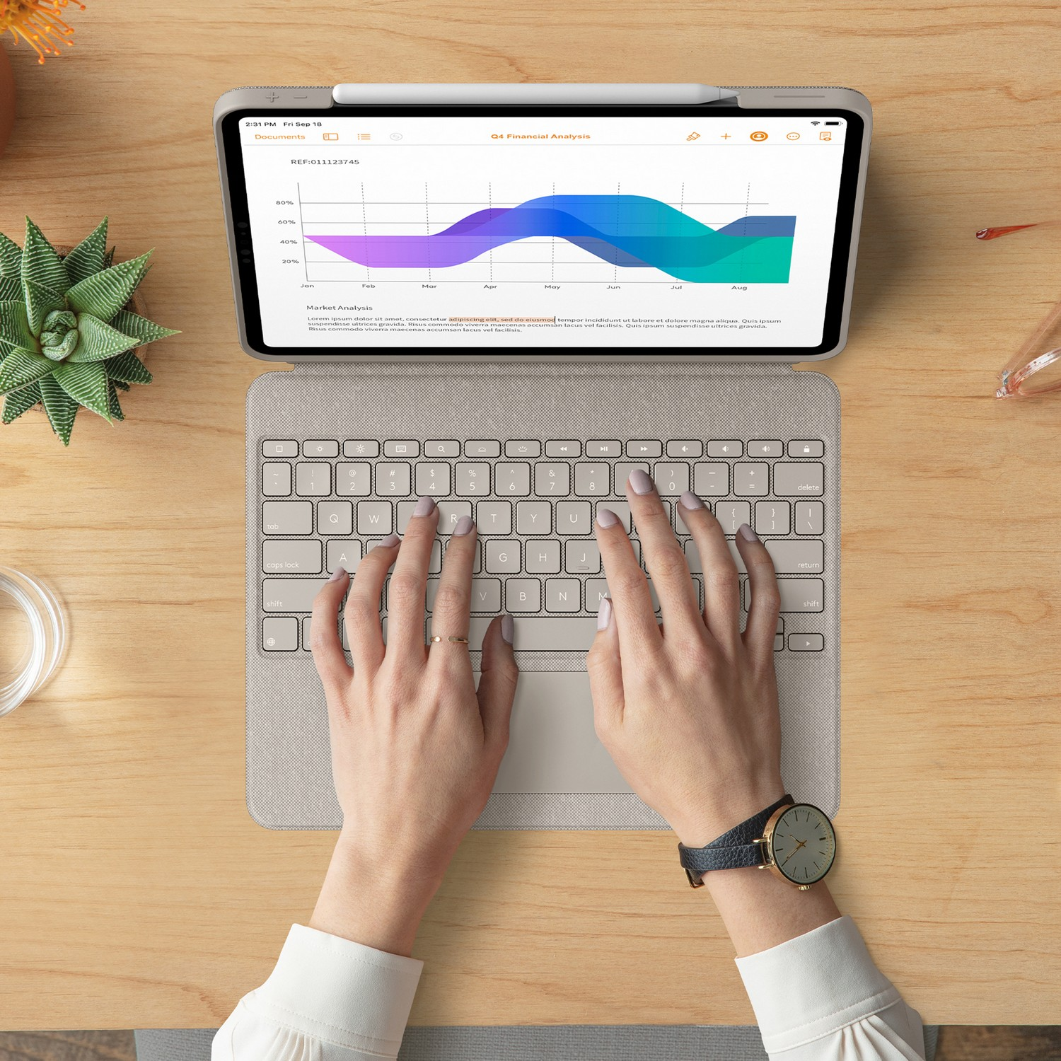 Personne utilisant une tablette avec un clavier attaché. L'écran affiche un graphique d'analyse financière.