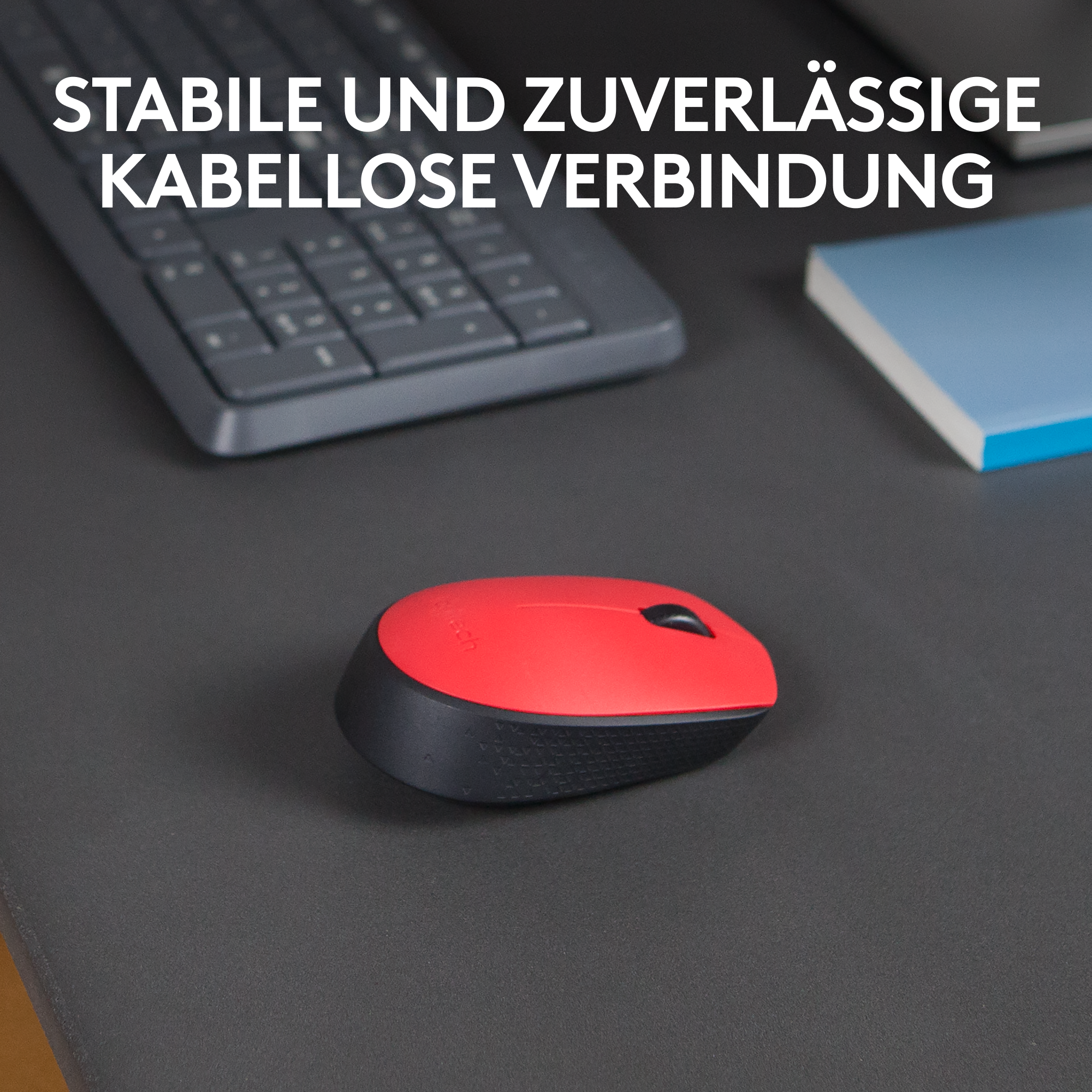 Rote und schwarze Maus auf einem dunkelgrauen Schreibtisch mit Text darüber.