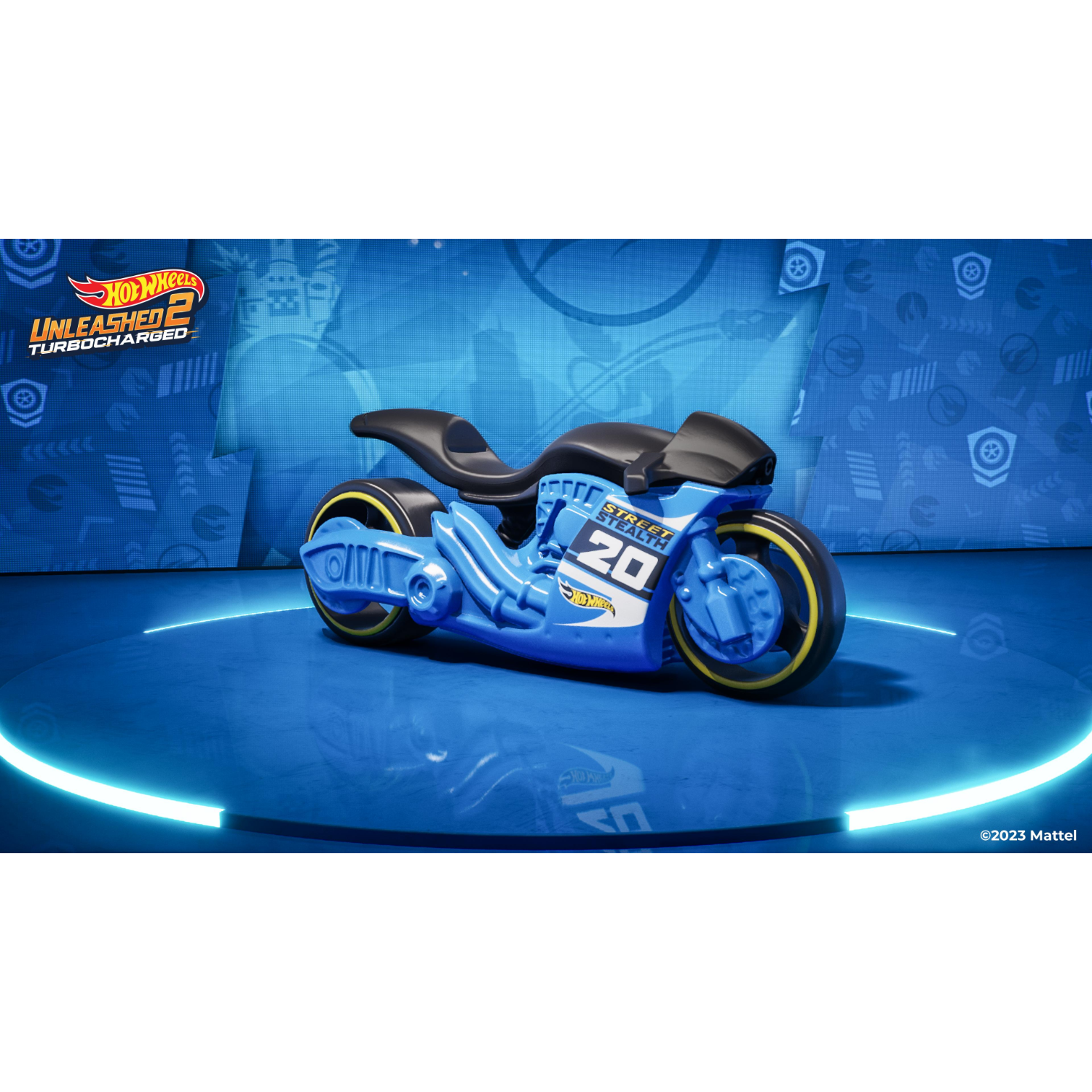 Een blauwe speelgoedmotor met gele wielen op een blauw platform met een logo.