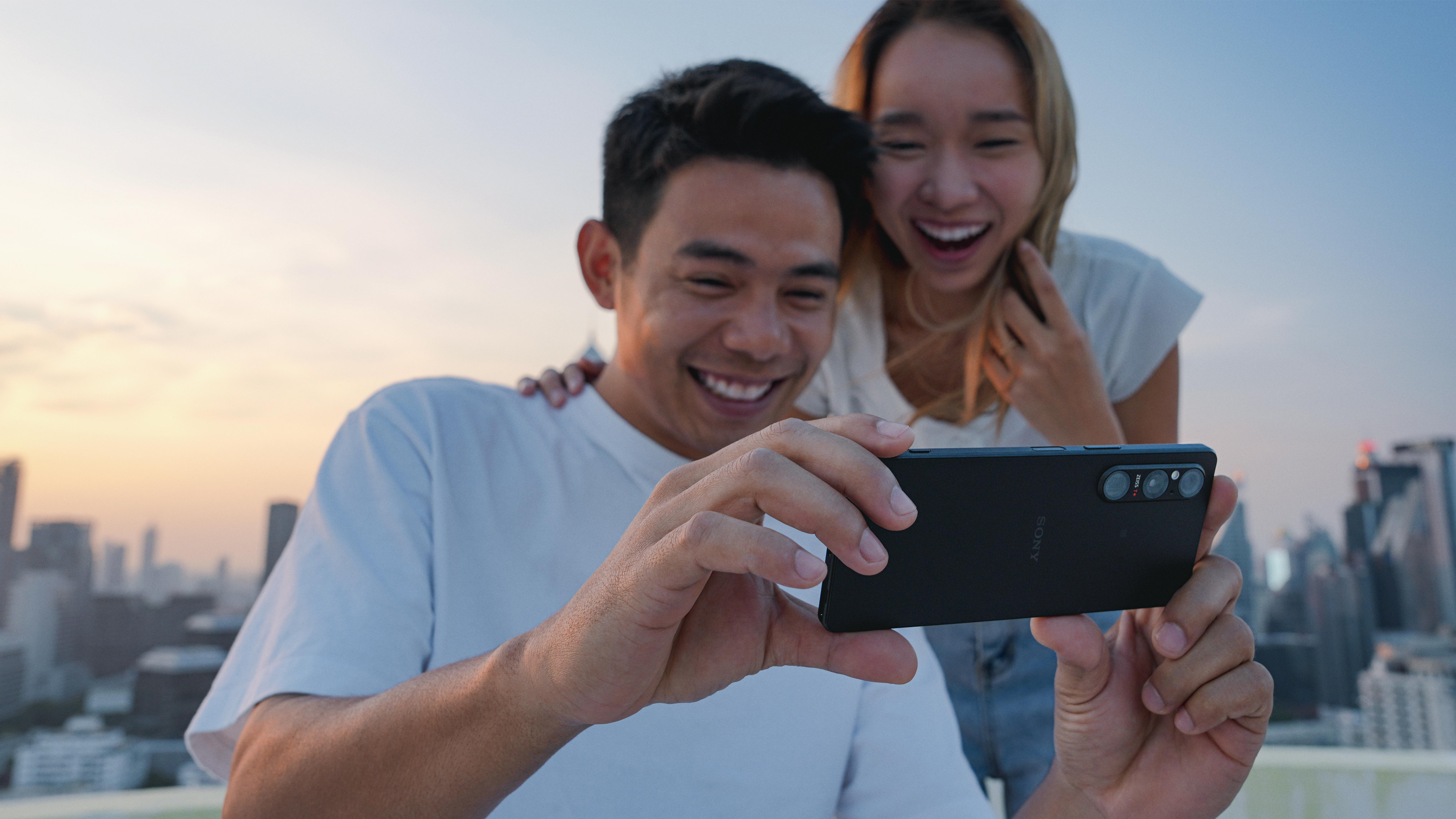 Zwei Personen machen ein Selfie mit einem Telefon.