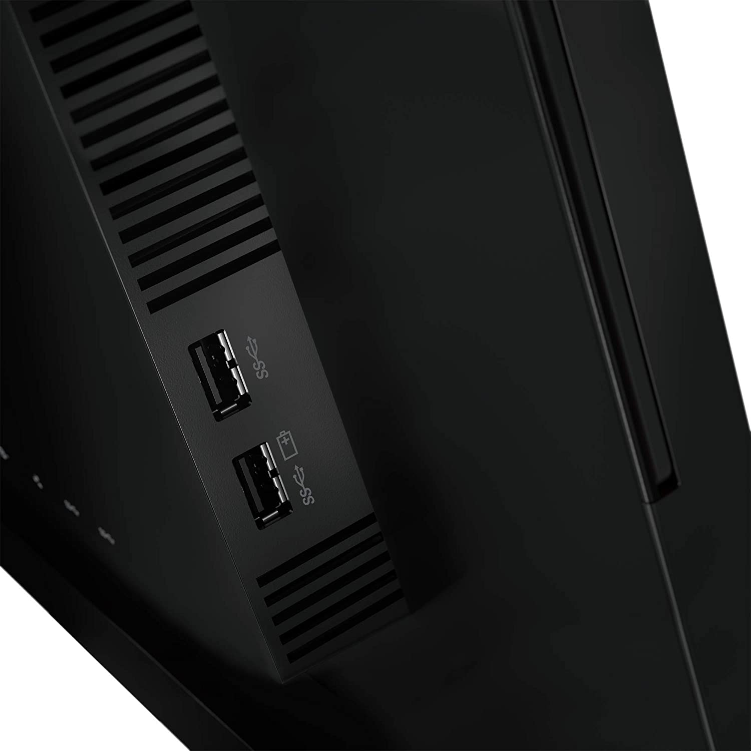 Primer plano de una computadora negra con puertos USB y una ventilación en su lateral.