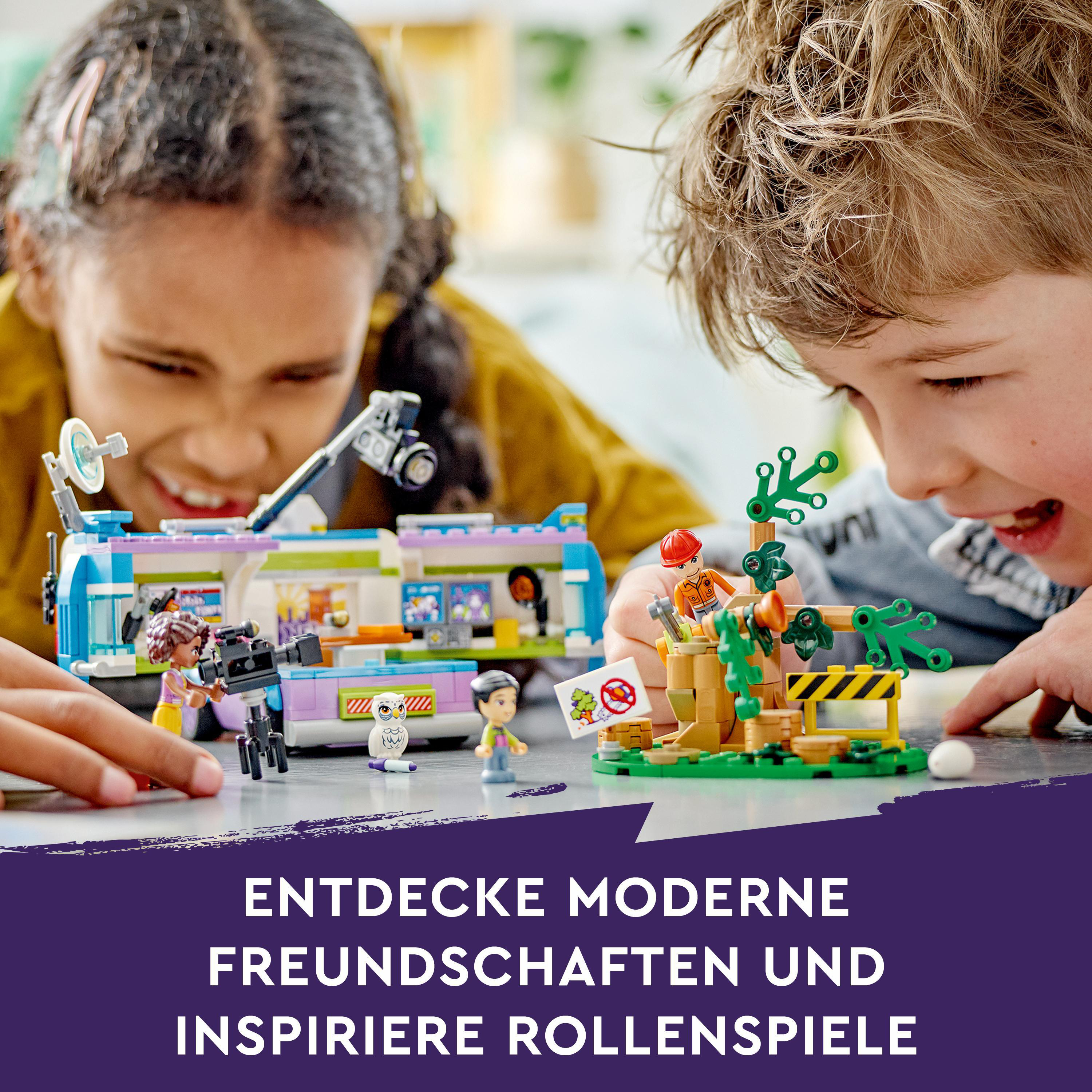 Kinder spielen mit Lego-Spielzeug. Eine Szene mit einem Bus und einem Baum mit Schildern.