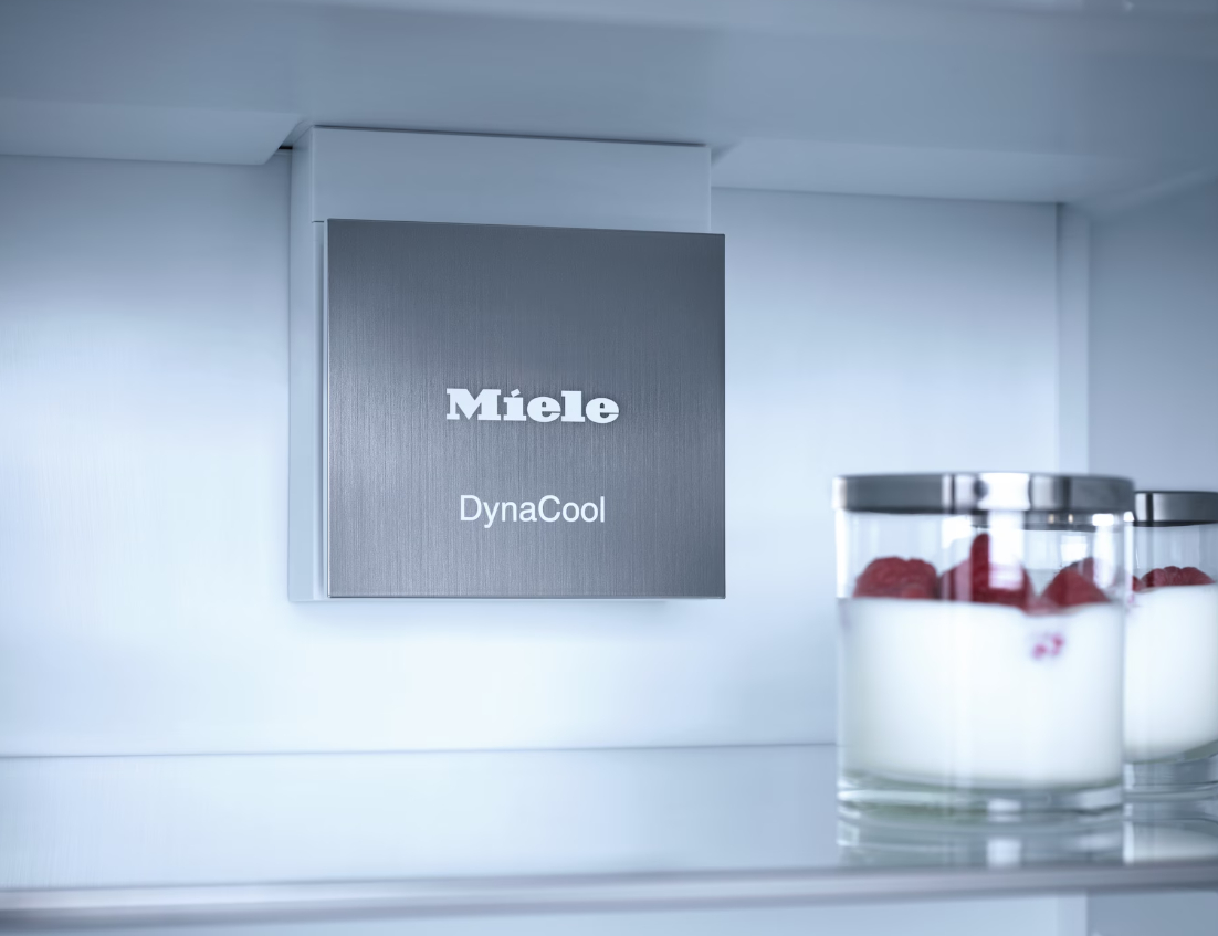 In einem Kühlschrank, eine silberne Miele DynaCool Platte und zwei Gläser mit Joghurt.