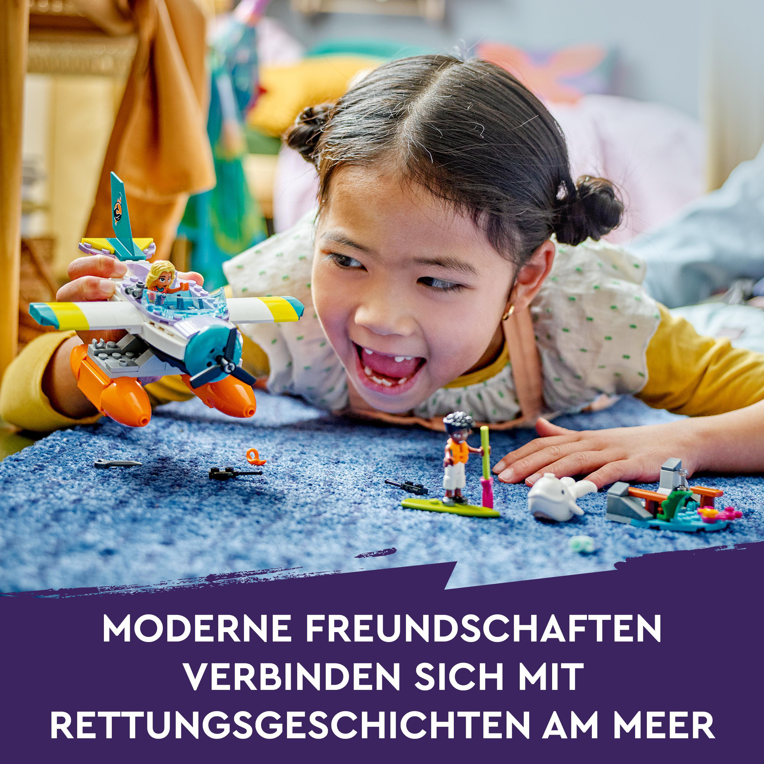 Ein Kind spielt mit einem Lego-Flugzeugspielzeug. Es ist ein helles und farbenfrohes Spielzeug in einer spielerischen Szene.