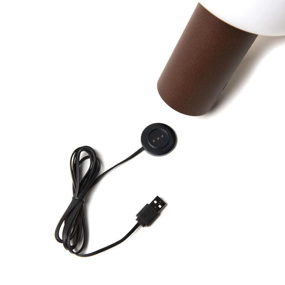 Ladestation einer Smartwatch und ein USB-Kabel mit weißem Hintergrund.