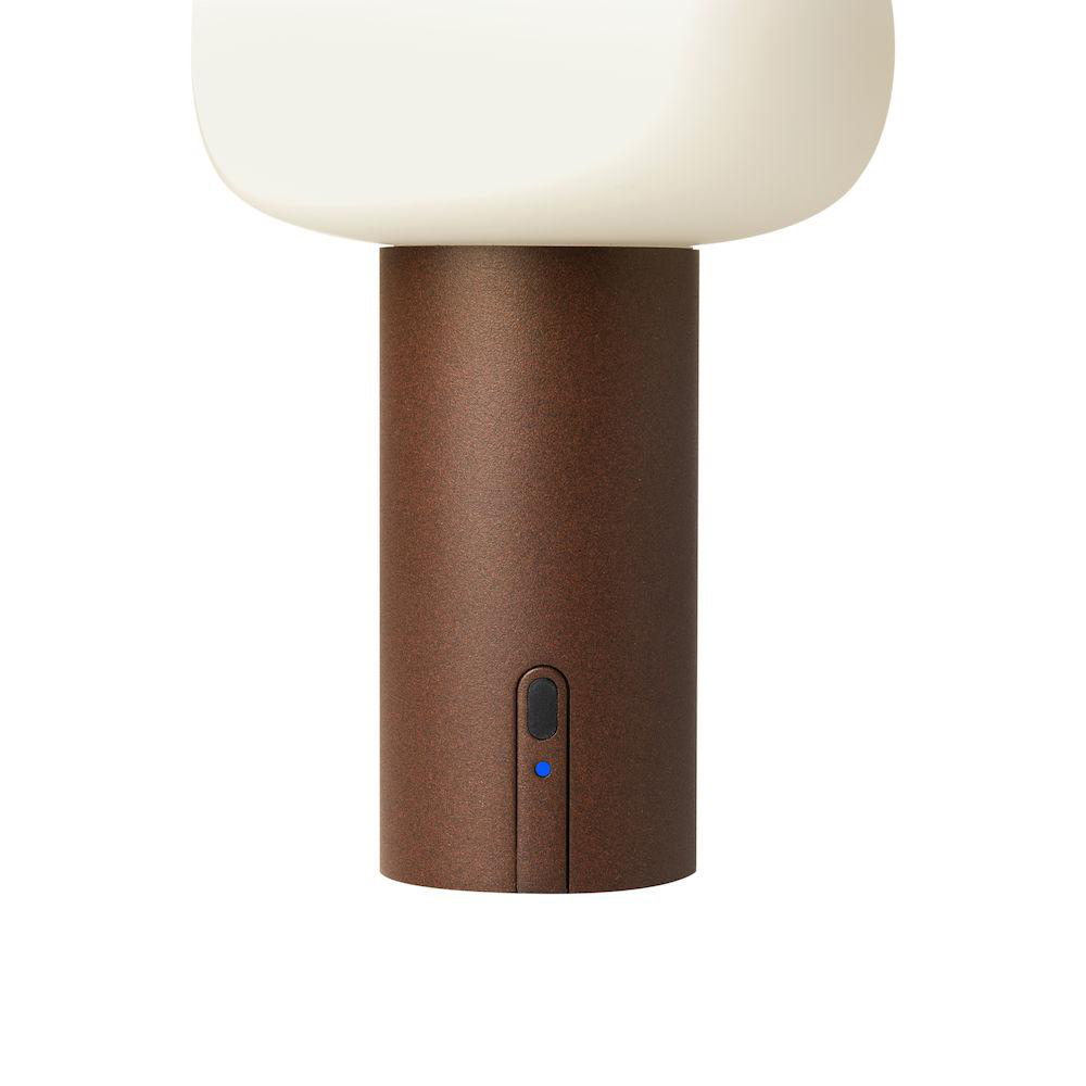 Eine braune und weiße pilzförmige Lampe mit blauem Licht am Sockel.