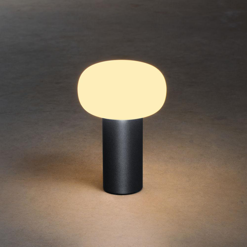Eine moderne, schwarze Tischlampe mit abgerundeter, beleuchteter Oberseite und zylindrischem Sockel.