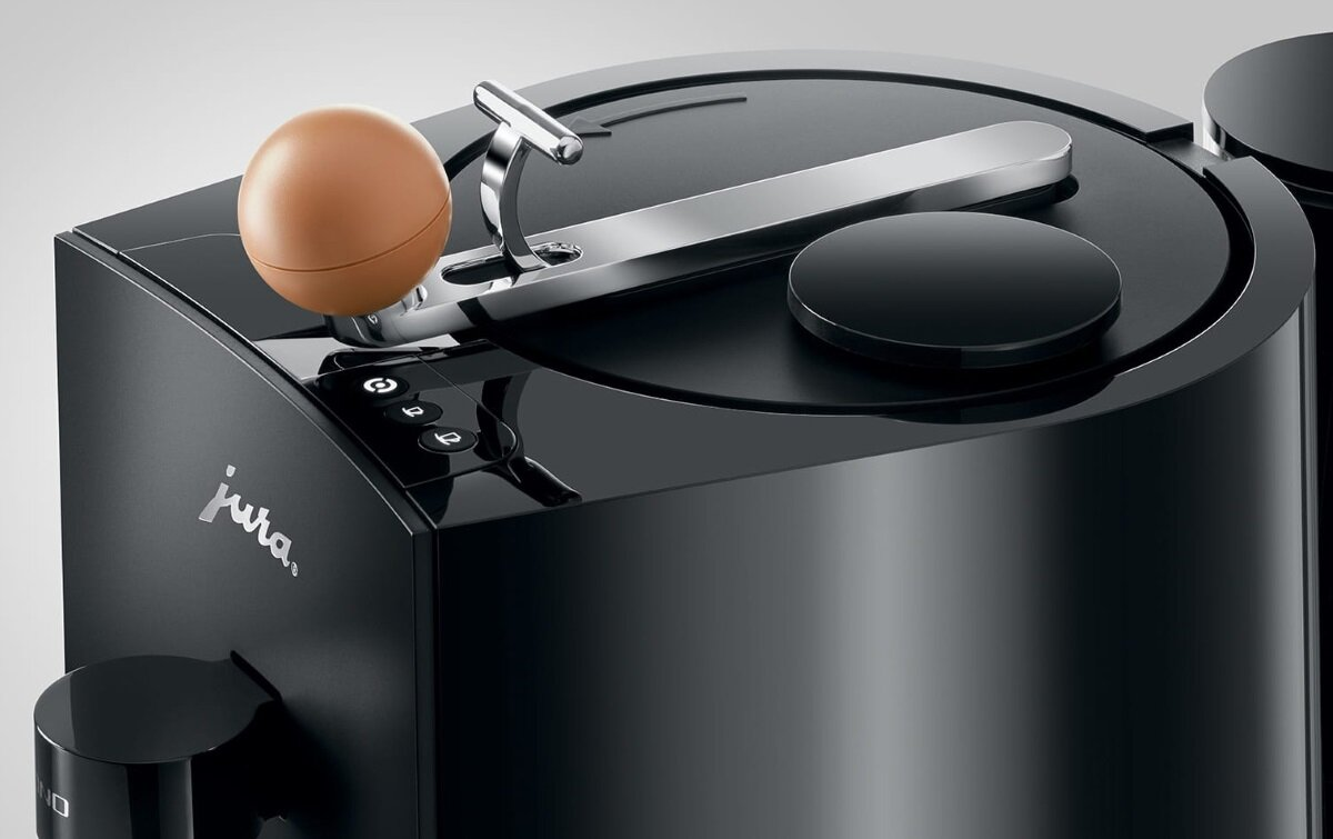 Czarny ekspres do kawy z drewnianym uchwytem i trzema przyciskami.