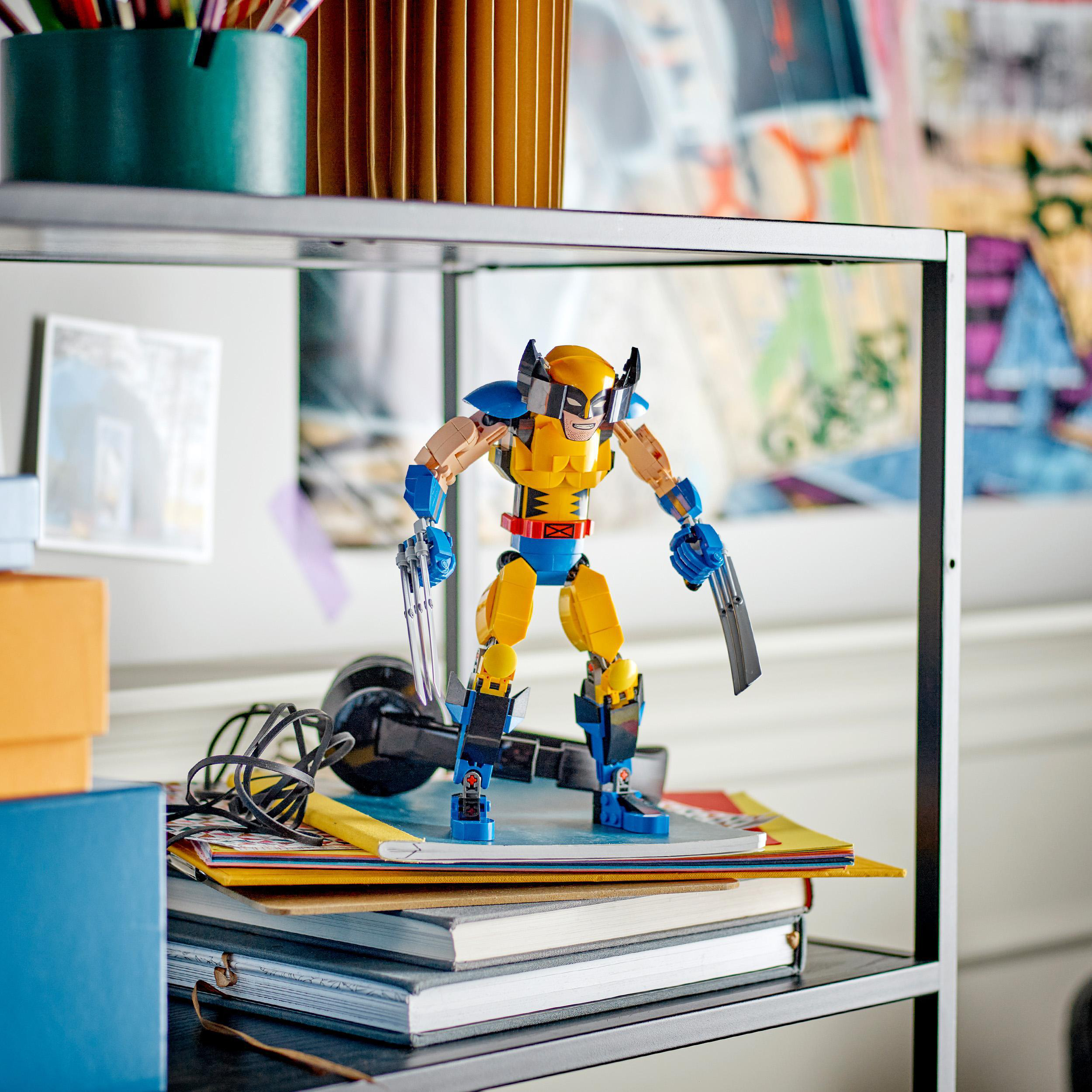 Eine Lego Wolverine-Figur auf einem Regal mit anderen Gegenständen. Die Figur ist gelb und blau.