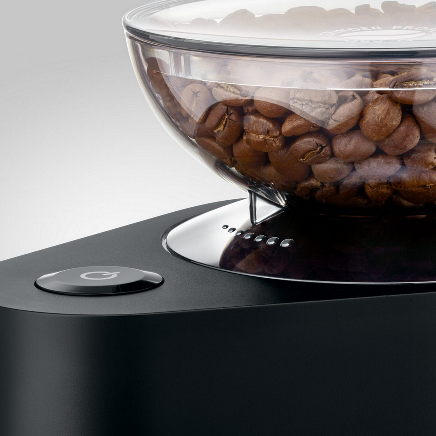 Close-up of a coffee grinder showing coffee beans and a power button.