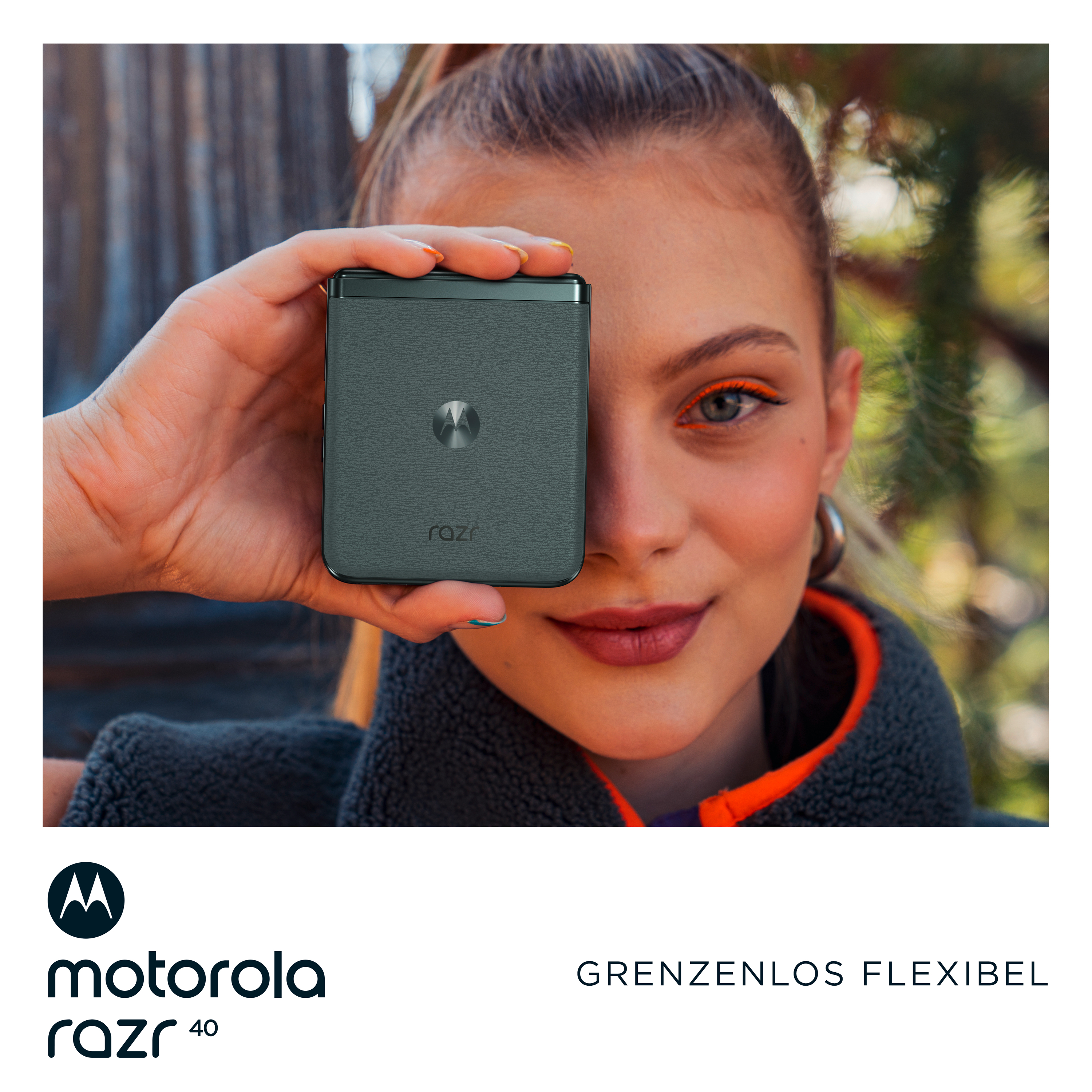 Eine Frau, die ein graues faltbares Telefon vor ihrem Auge hält, lächelt, und ein Logo.