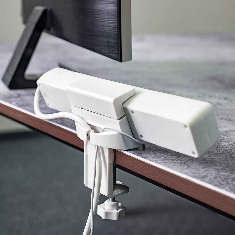 Witte bureaulamp met een klem, op een tafel gemonteerd.