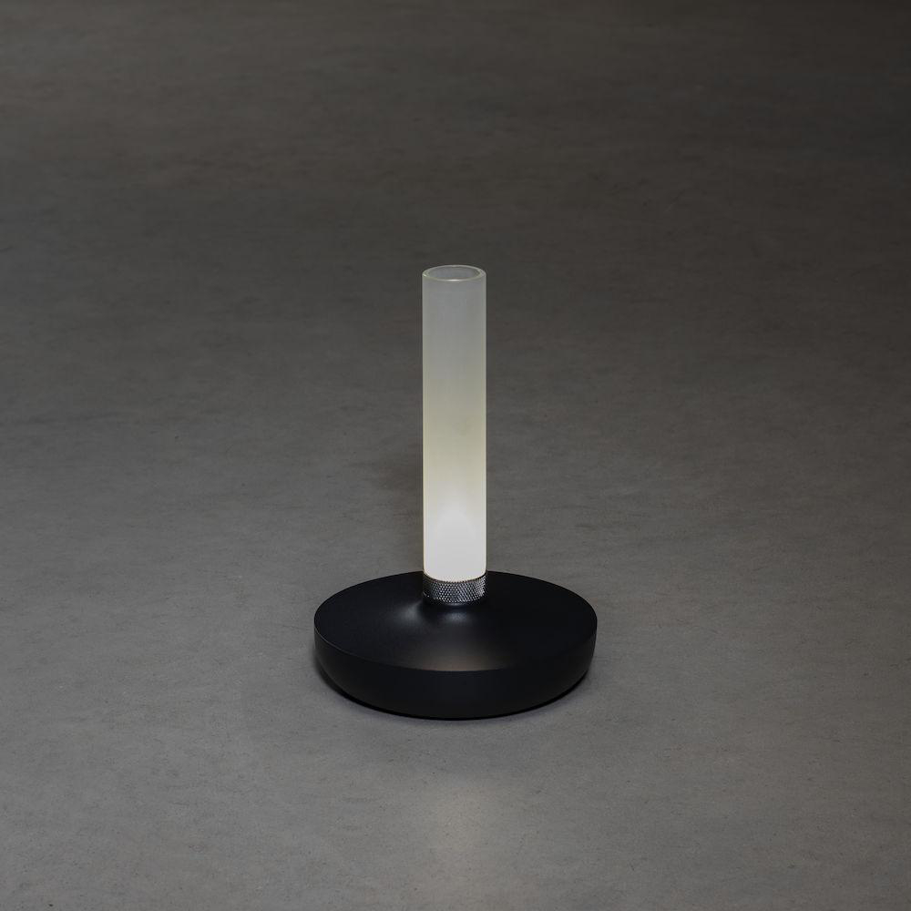 Ein schwarzer, kreisförmiger Lampenfuß mit einem weißen Lichtrohr. Der Hintergrund ist grau.
