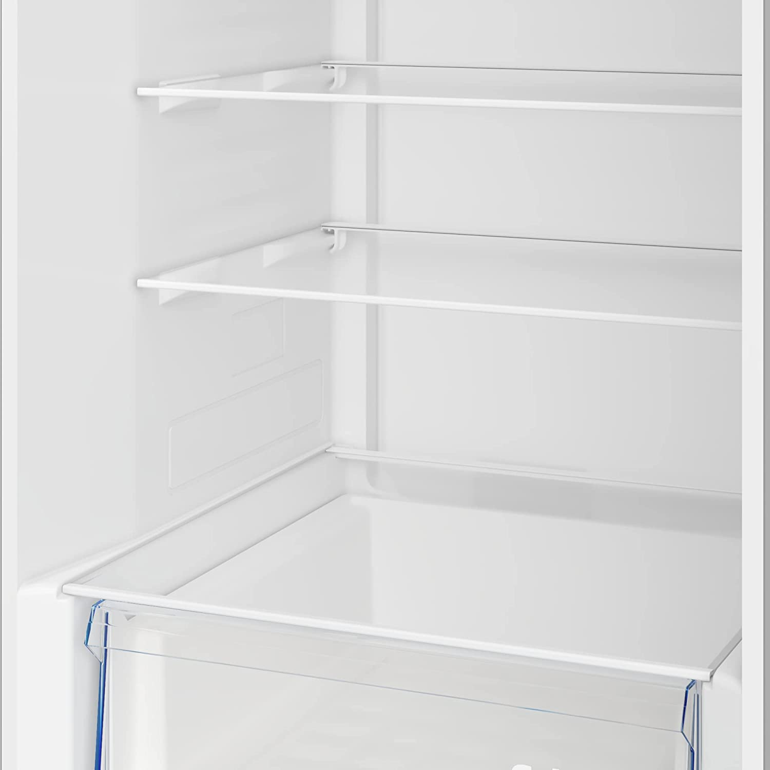 Interior de un refrigerador blanco. Estantes y un cajón son visibles, todos están vacíos.