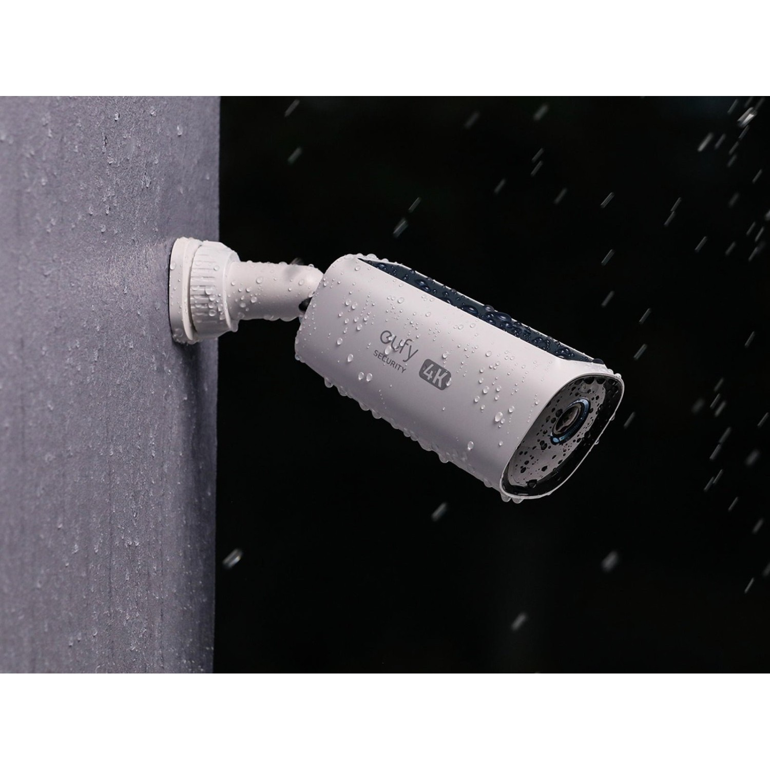 White security camera mounted on a wall, covered in water droplets.