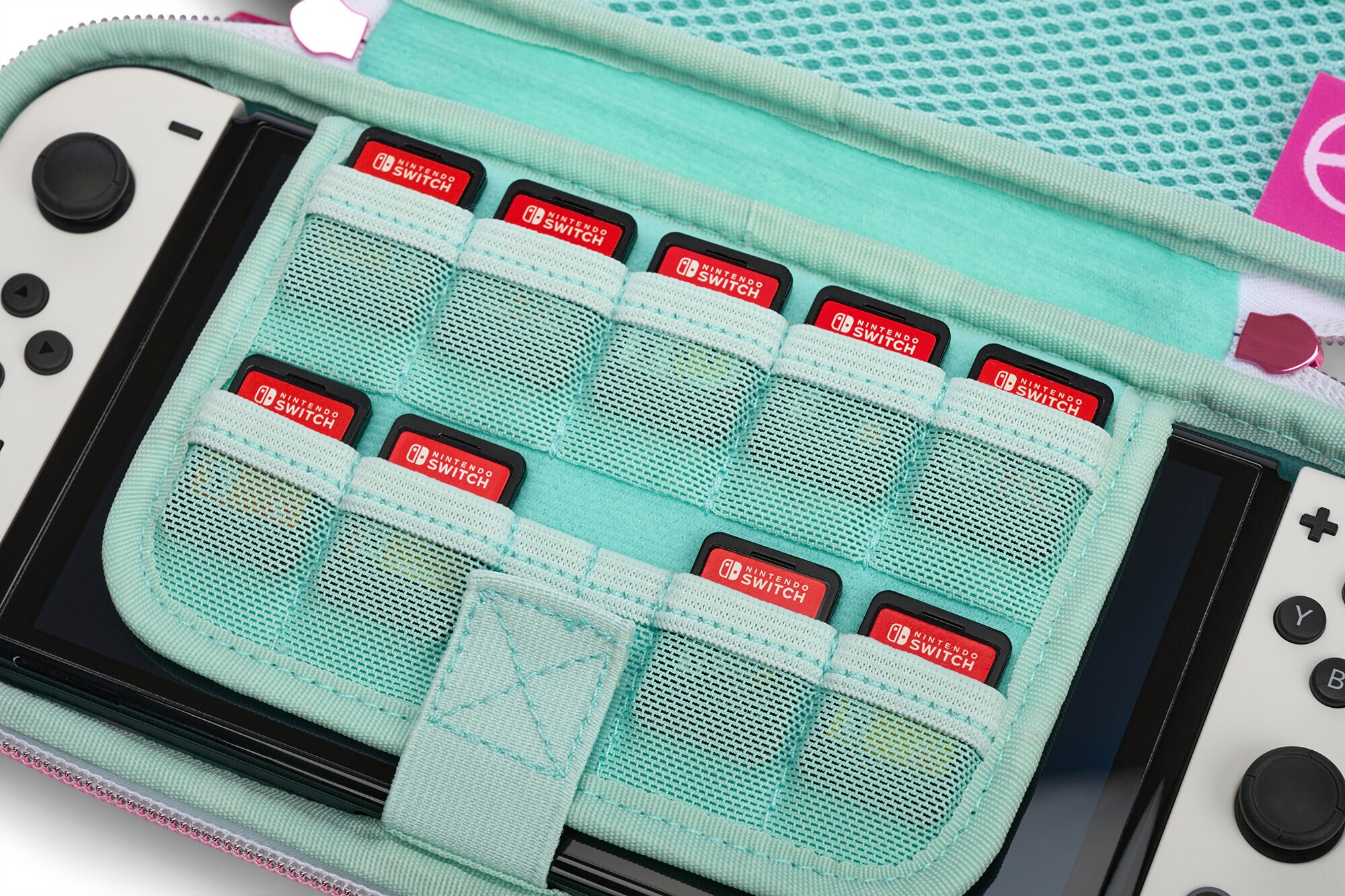 Konsola Nintendo Switch i karty do gier wewnątrz miętowego etui. Etui jest otwarte.