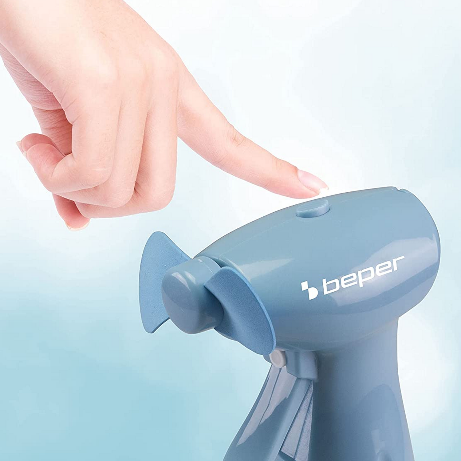 Een hand drukt op een knop van een blauwe draagbare ventilator. De ventilator heeft een blauw blad en het woord beper.