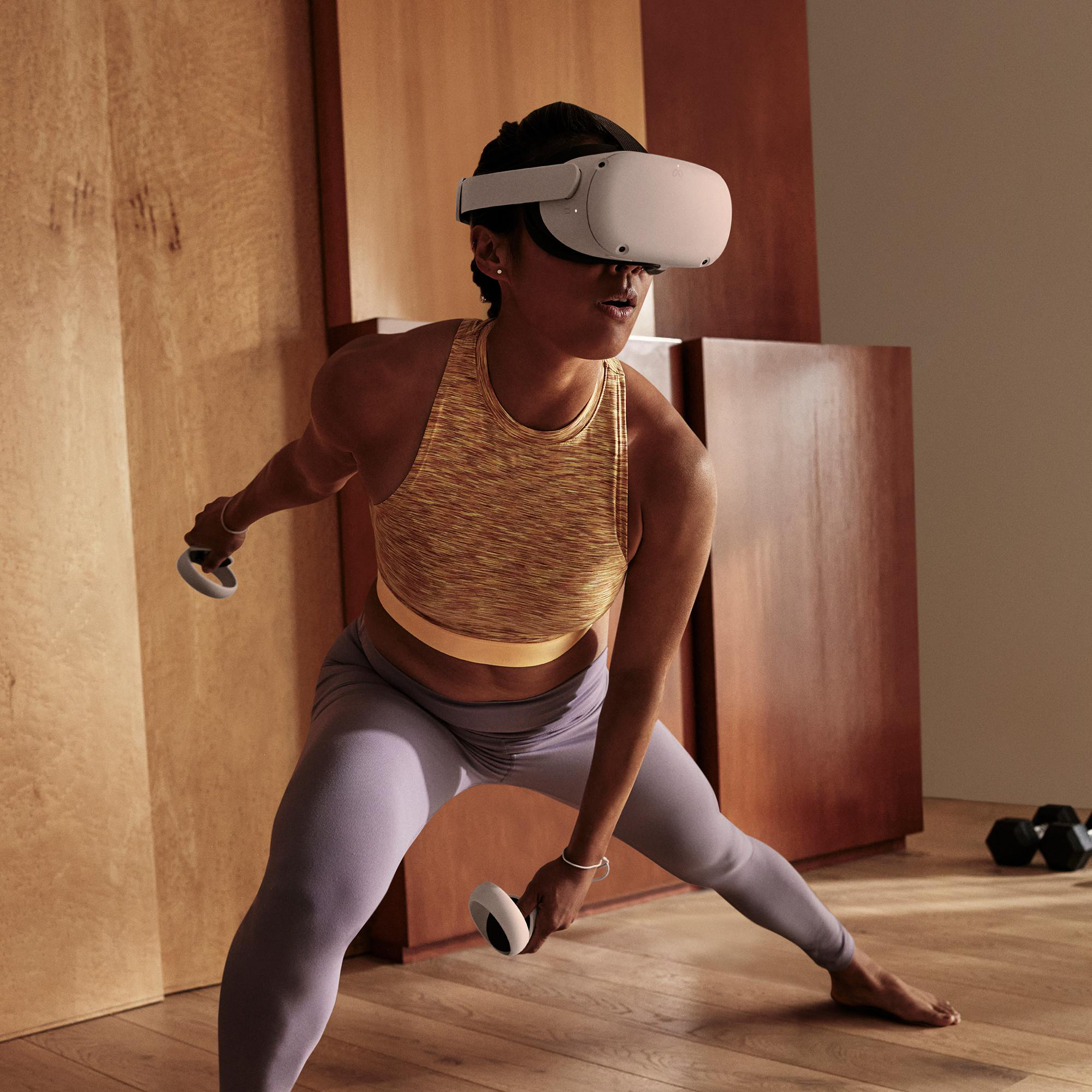 Frau mit VR-Headset, Kniebeugen mit Hanteln, in einem holzgetäfelten Raum.
