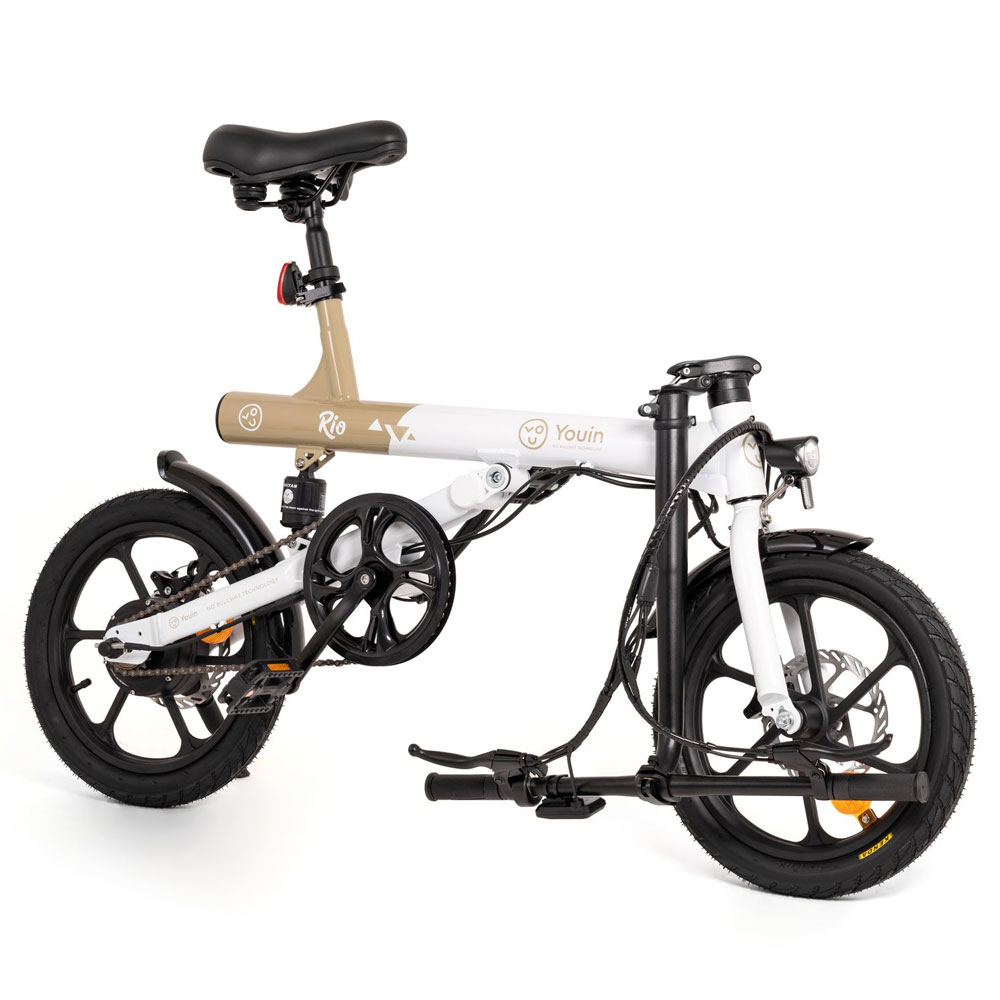 Bicicleta eléctrica plegable. Tiene un cuadro blanco y beige, neumáticos y componentes negros.