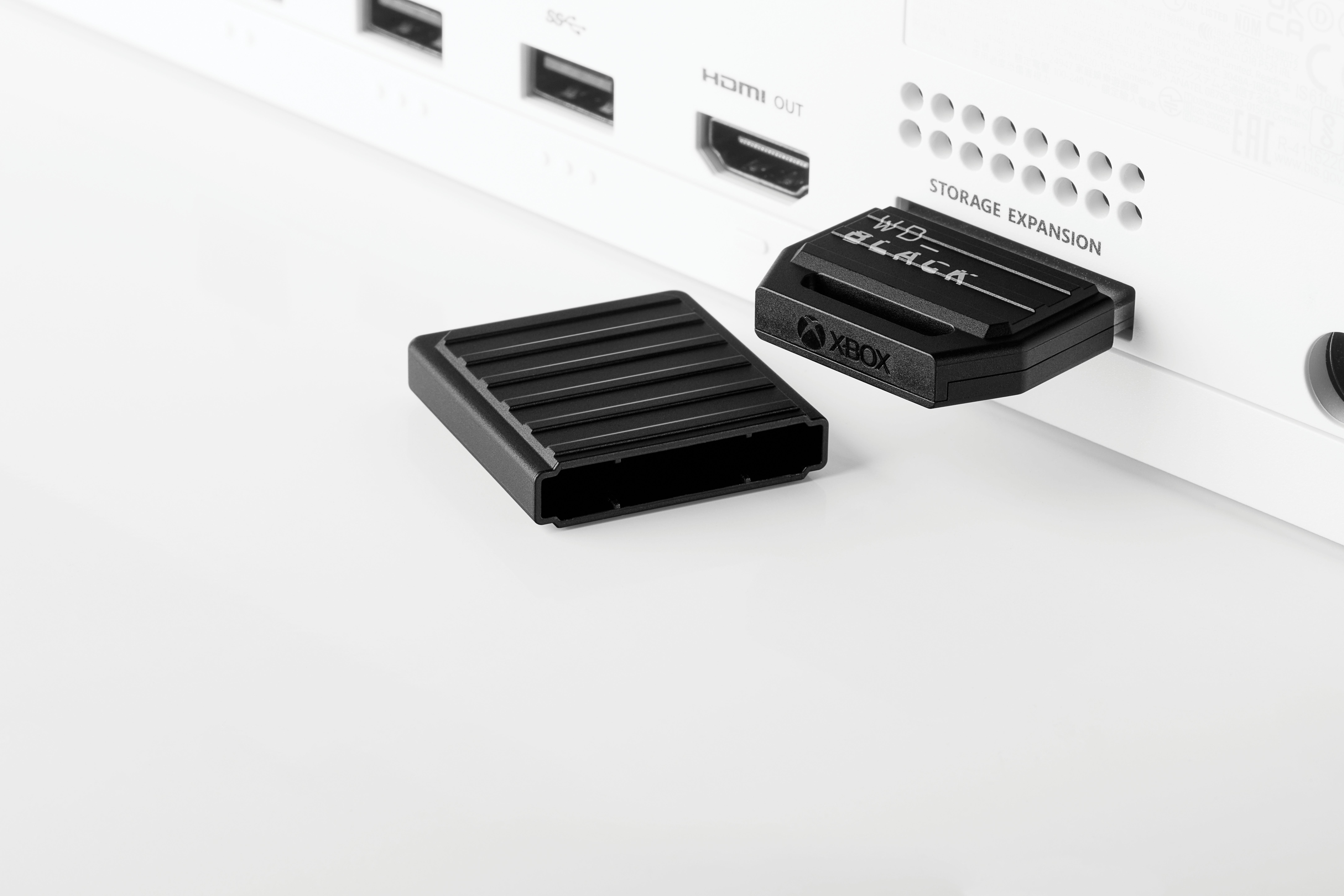 Xbox Series X mit eingesetzter Speichererweiterungskarte und abgenommener Abdeckung.