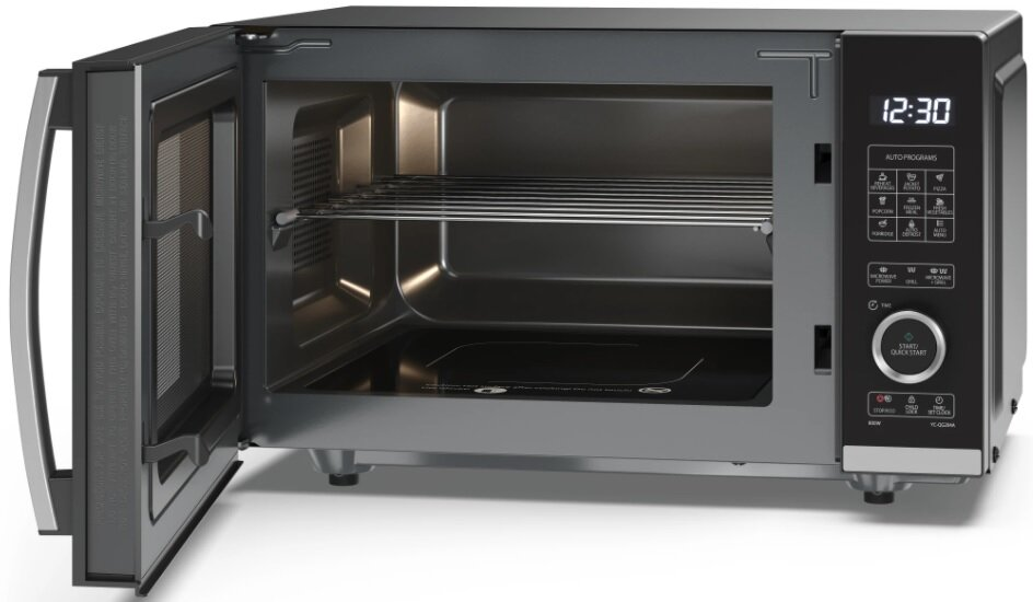Kuchenka mikrofalowa z otwartymi drzwiami. Wewnątrz widoczny metalowy ruszt i czarna podstawa. Panel sterowania pokazuje godzinę.