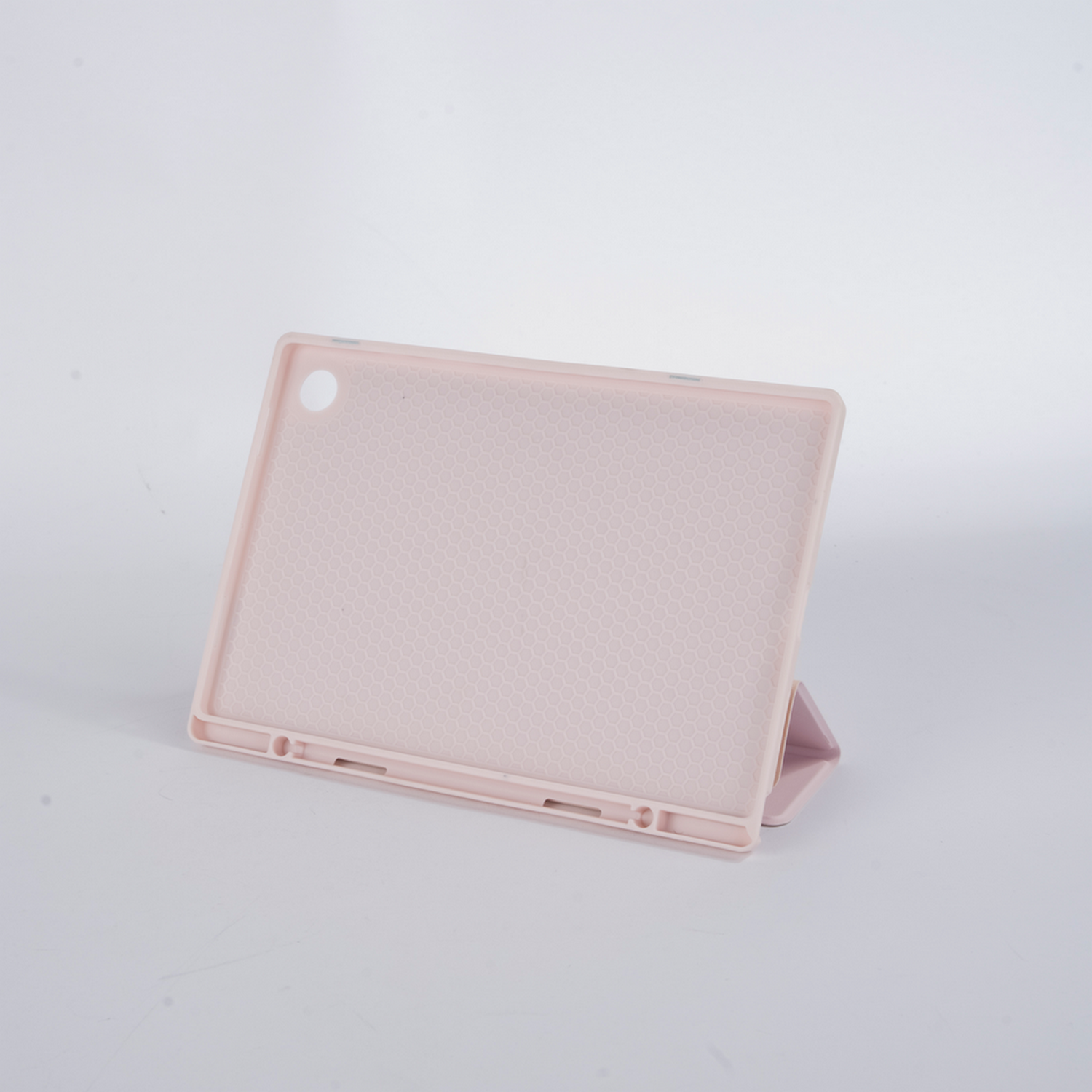 Een lichtroze tablethoes, open en opgeklapt om te bekijken, op een witte achtergrond.