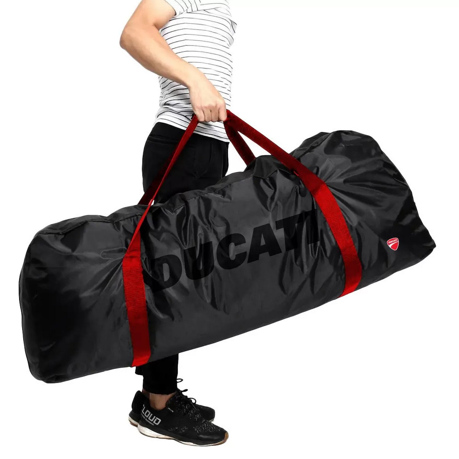Personne tenant un sac Ducati noir avec des sangles rouges, plein de choses. Fond blanc.