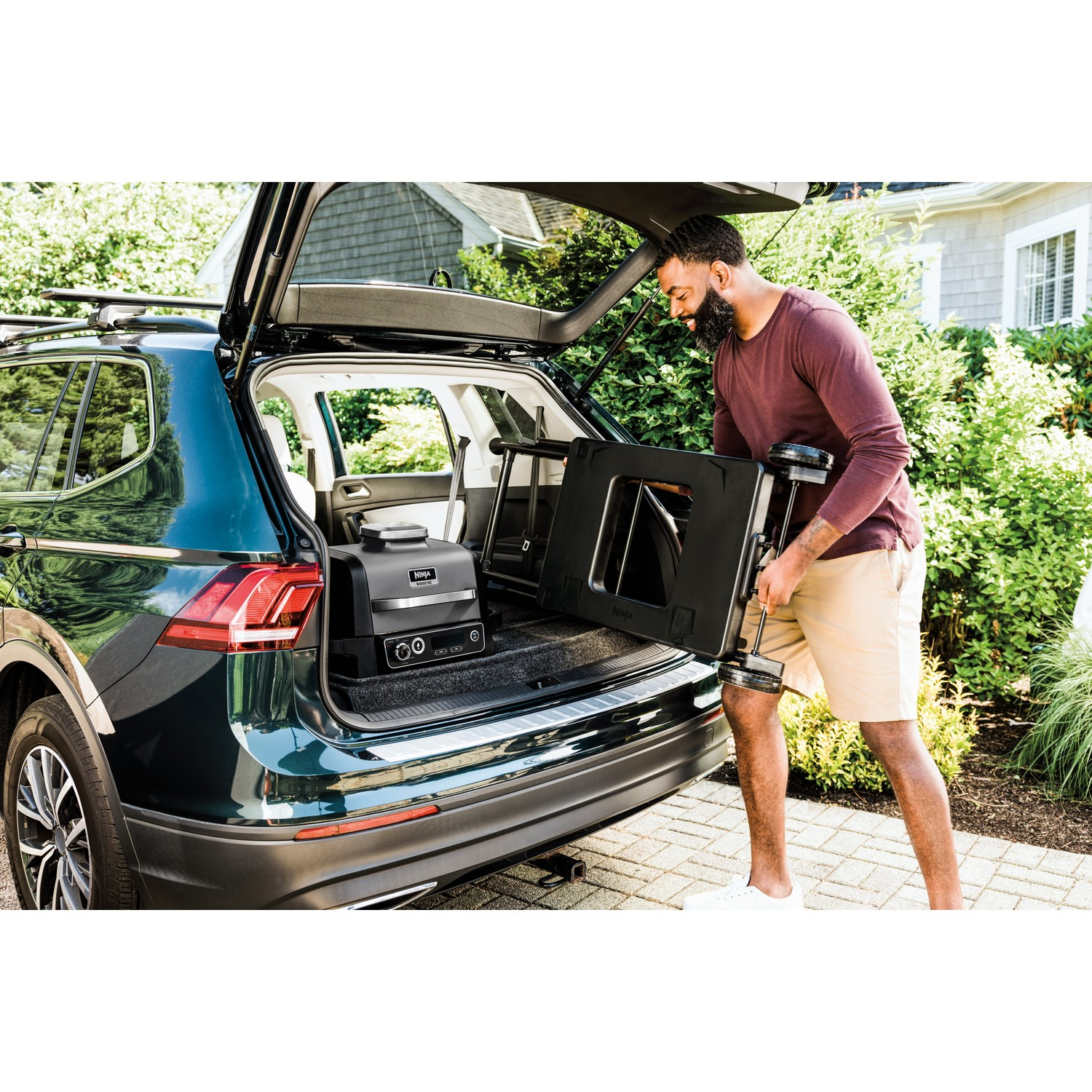 Homme chargeant une station d'alimentation portable noire et un chariot dans le coffre.