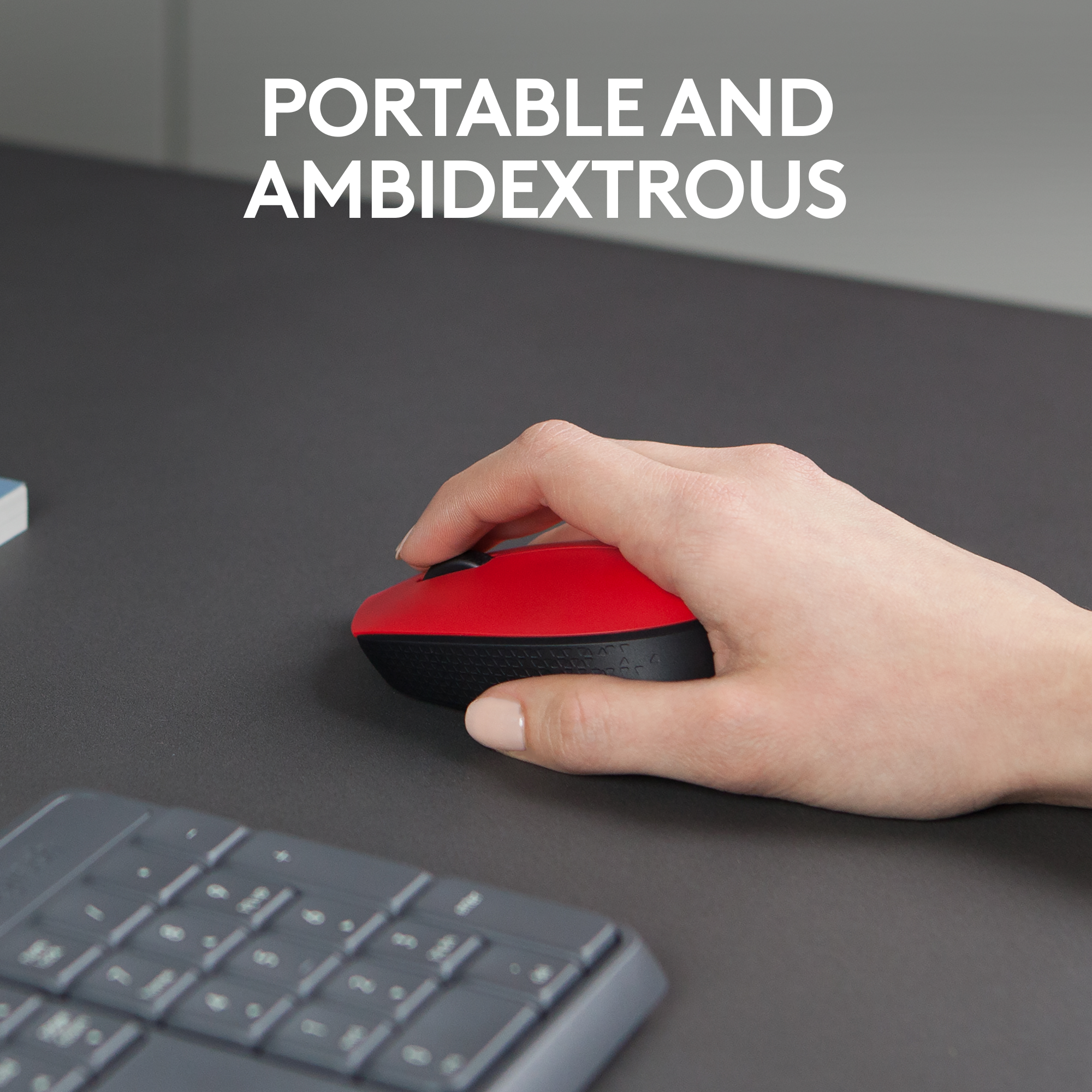 La main d'une personne tenant une souris rouge et noire. Texte : Portable et ambidextre.