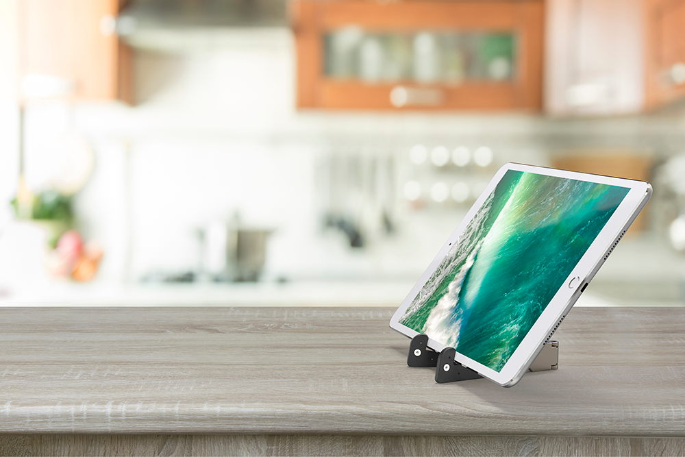Tablet placed on a wooden surface in a kitchen setting.