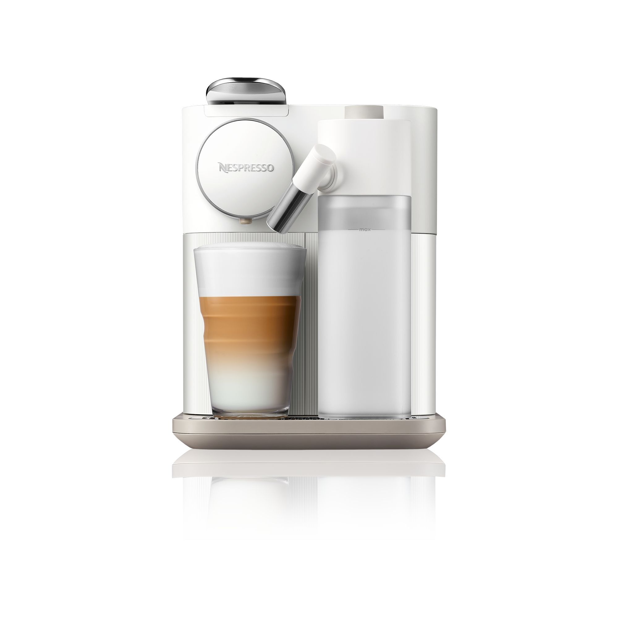 Beyaz Nespresso kahve makinesi ve bir bardak latte. Bir süt köpürtücü ve su deposu da görülebilir.