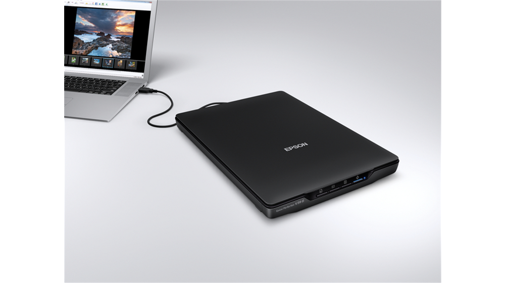 Epson-Scanner an Laptop angeschlossen, auf weißer Oberfläche, Foto angezeigt.