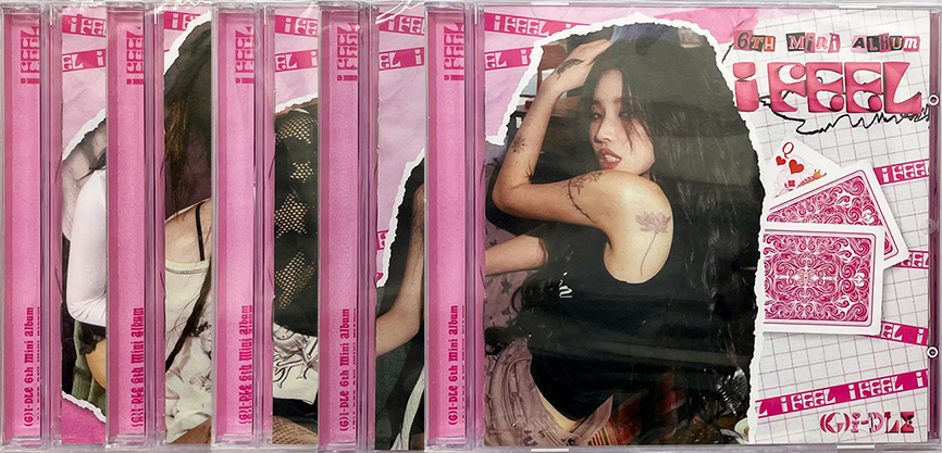K-pop album CD-k gyűjteménye, egy nővel az egyik album borítóján.