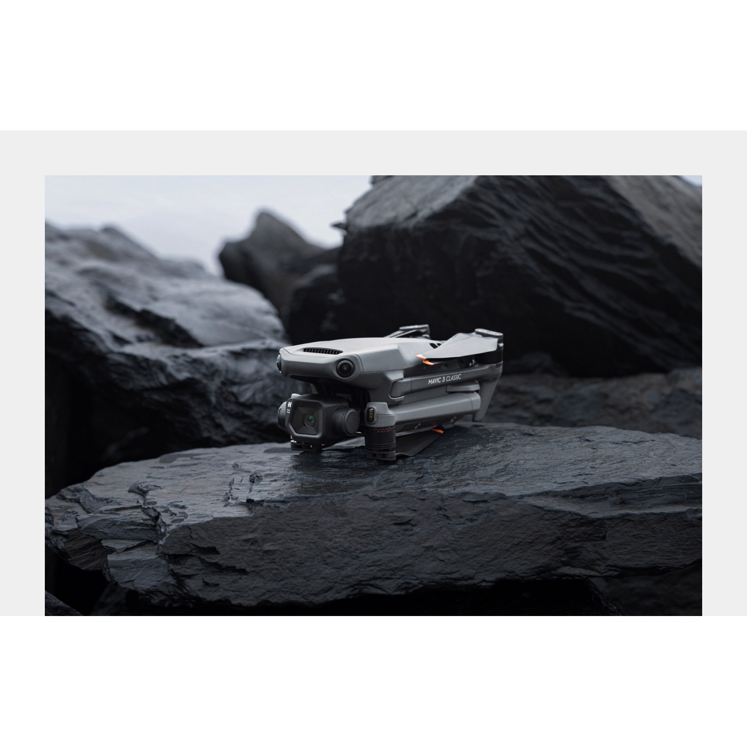 Een drone op een zwarte rots. De drone is donkergrijs en heeft een camera.