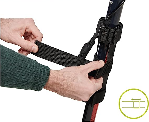 Mani che attaccano una cinghia a un monopattino nero. La cinghia ha una chiusura in velcro.