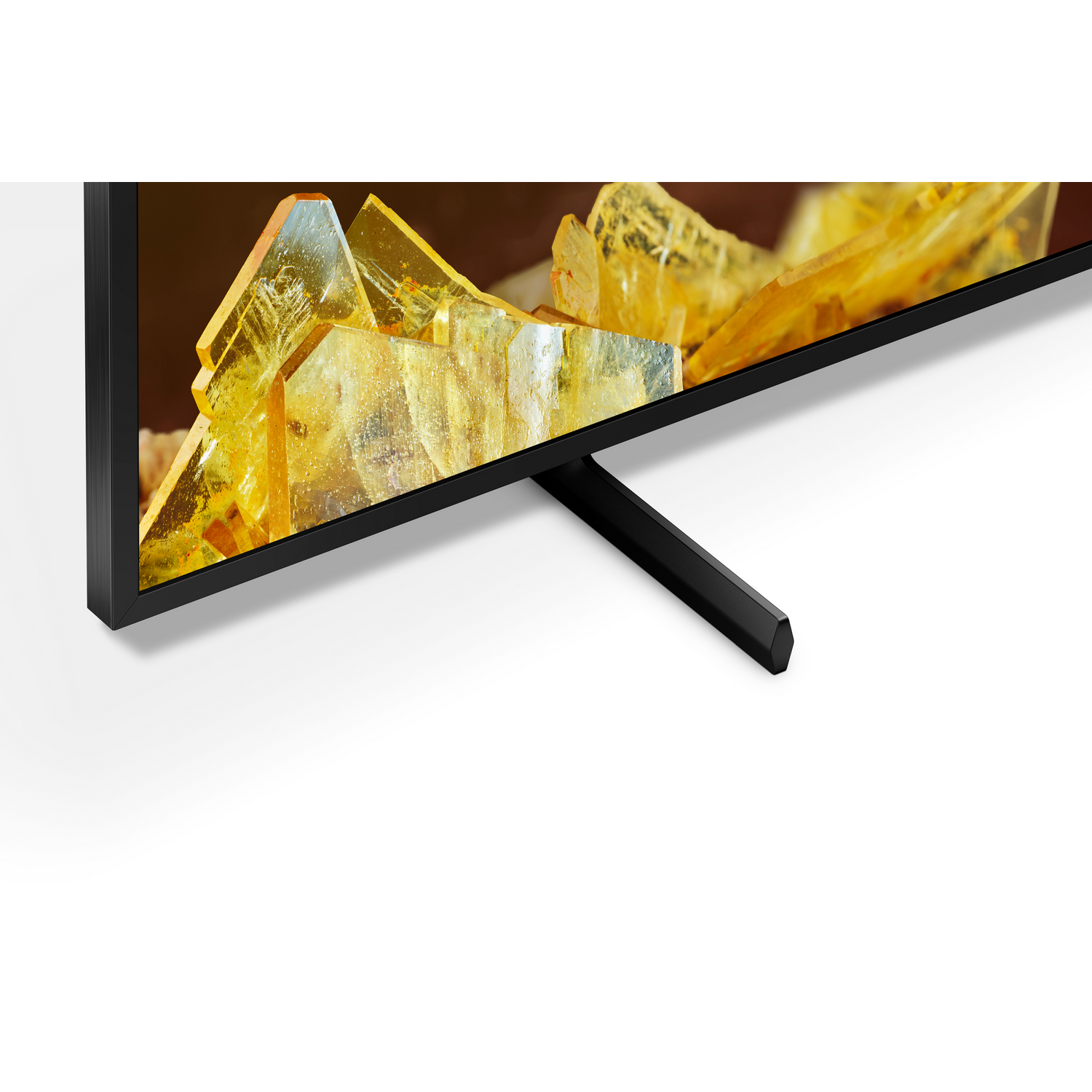 Close-up van tv met zwart frame en standaard, een geel kristalachtig beeld op het scherm.