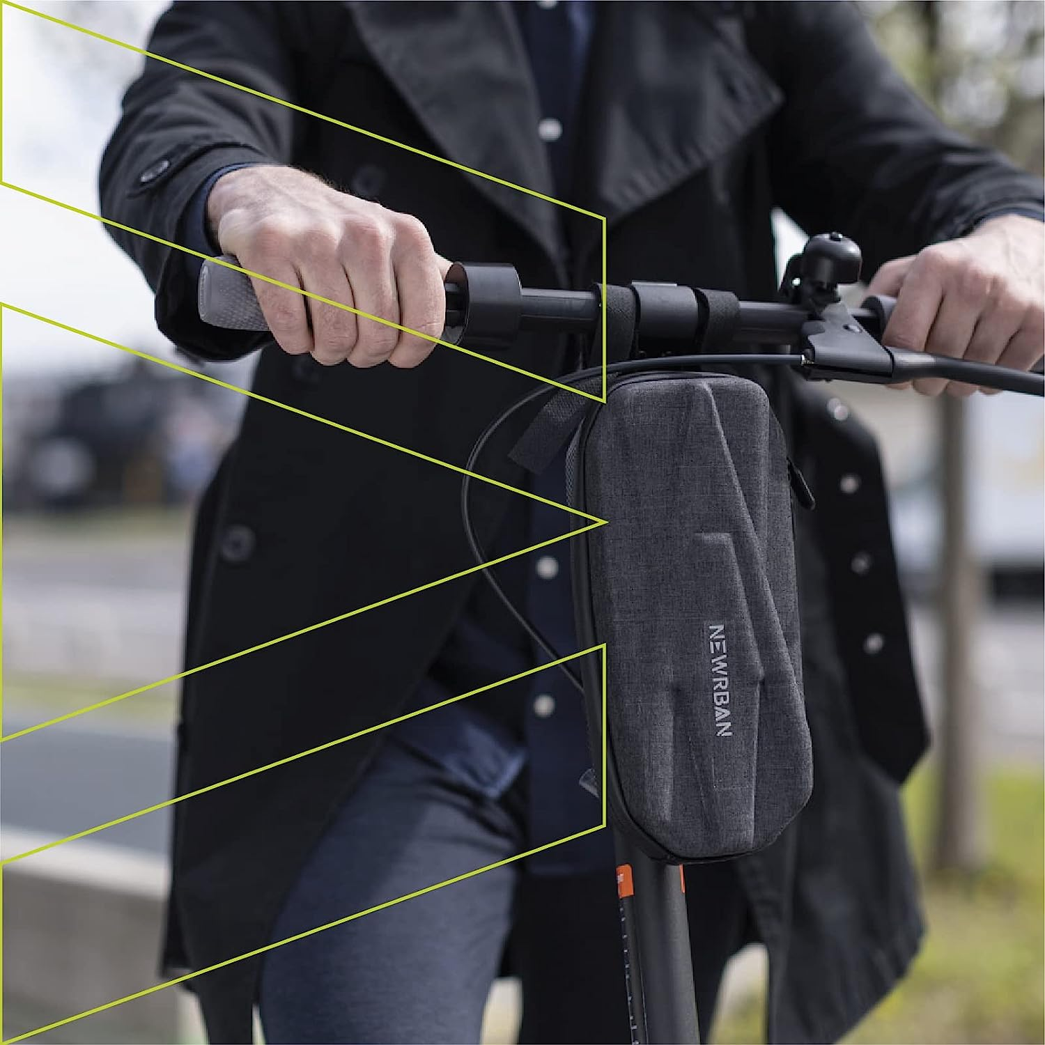 Personne tenant le guidon d'une trottinette avec sac attaché. Manteau noir visible.