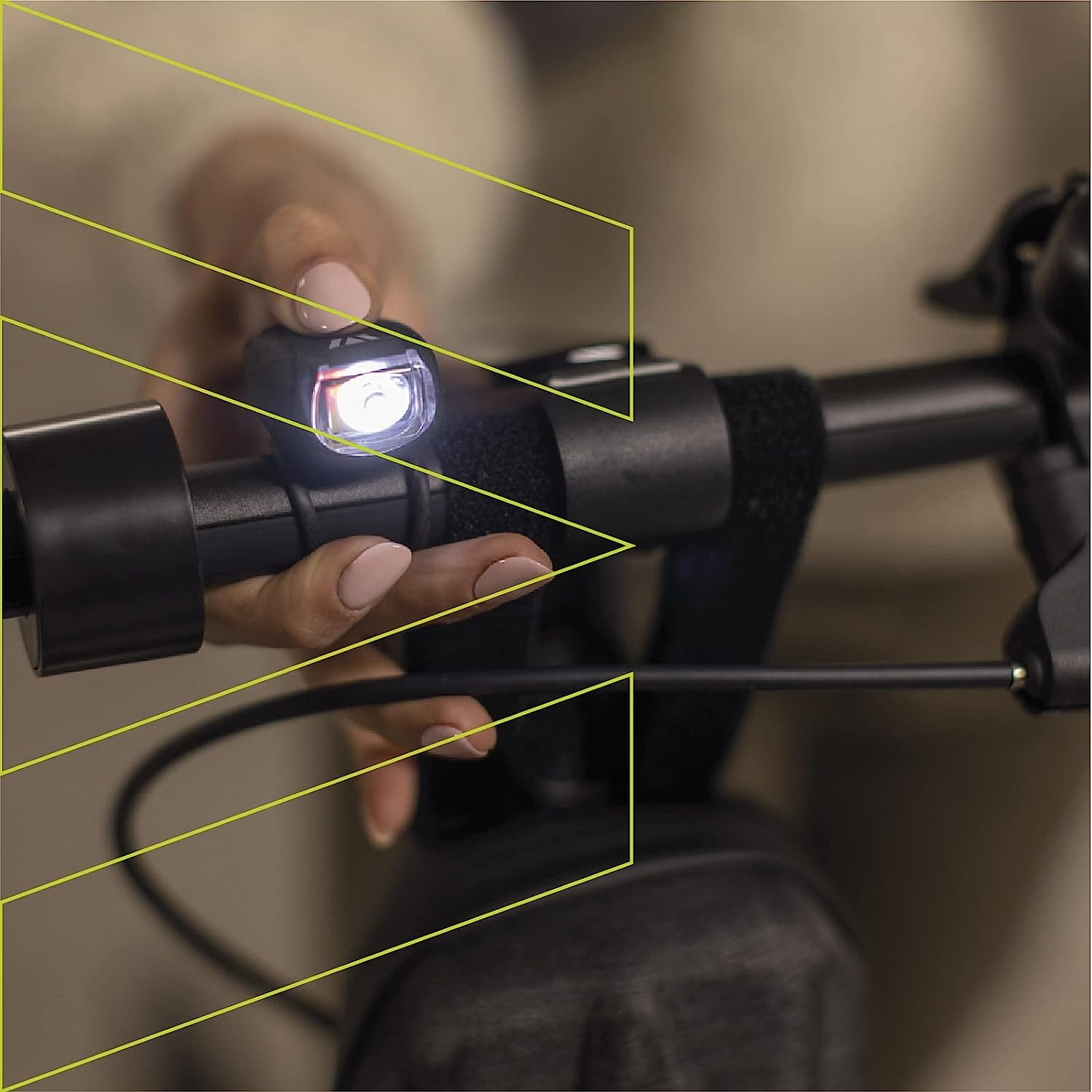 Mano di una persona che regola una luce per scooter, primo piano, con evidenziatori gialli.