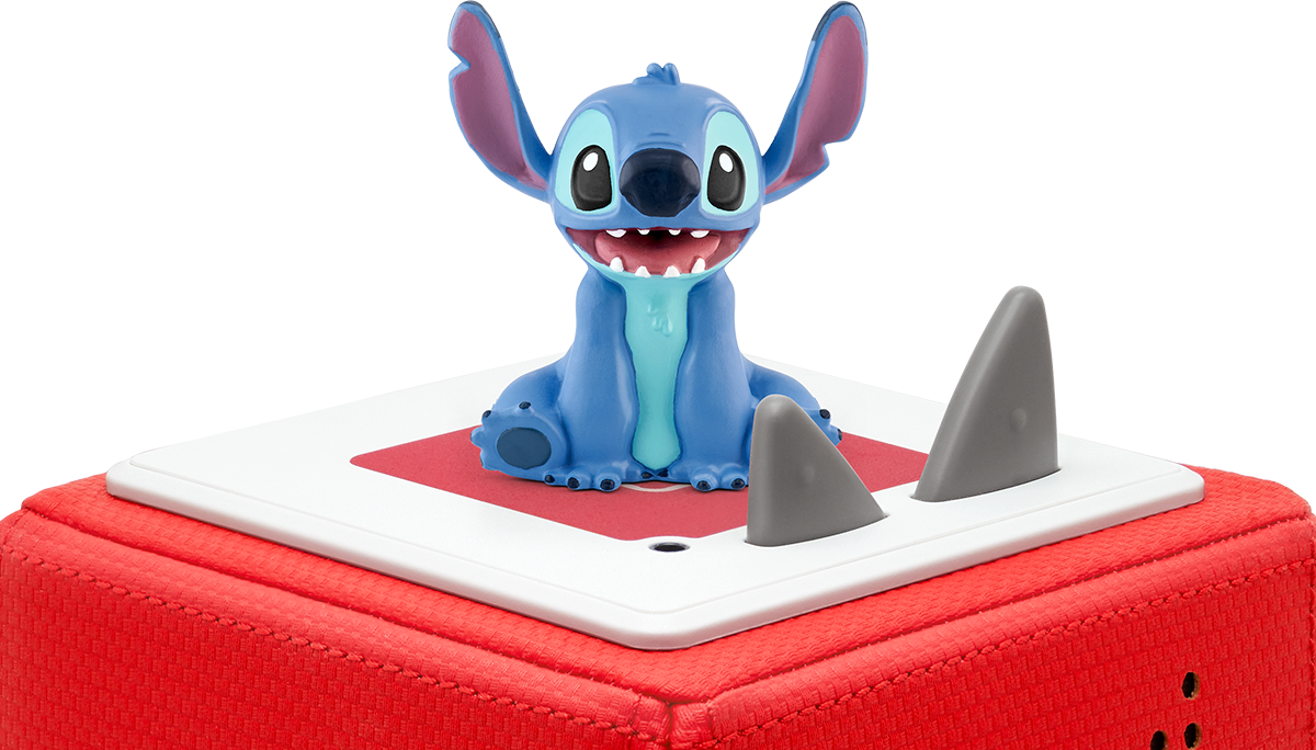 Eine blaue Stitch-Figur auf einer roten Box, mit zwei Hai-Flossen-Dekorationen.