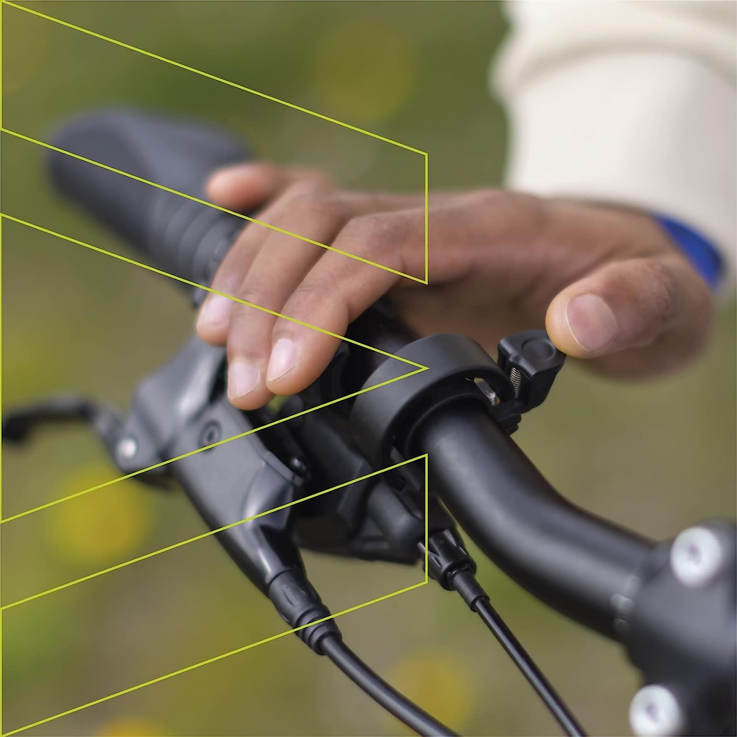 La mano di una persona che tiene il manubrio di una bicicletta. L'attenzione è sulla mano e sui comandi.