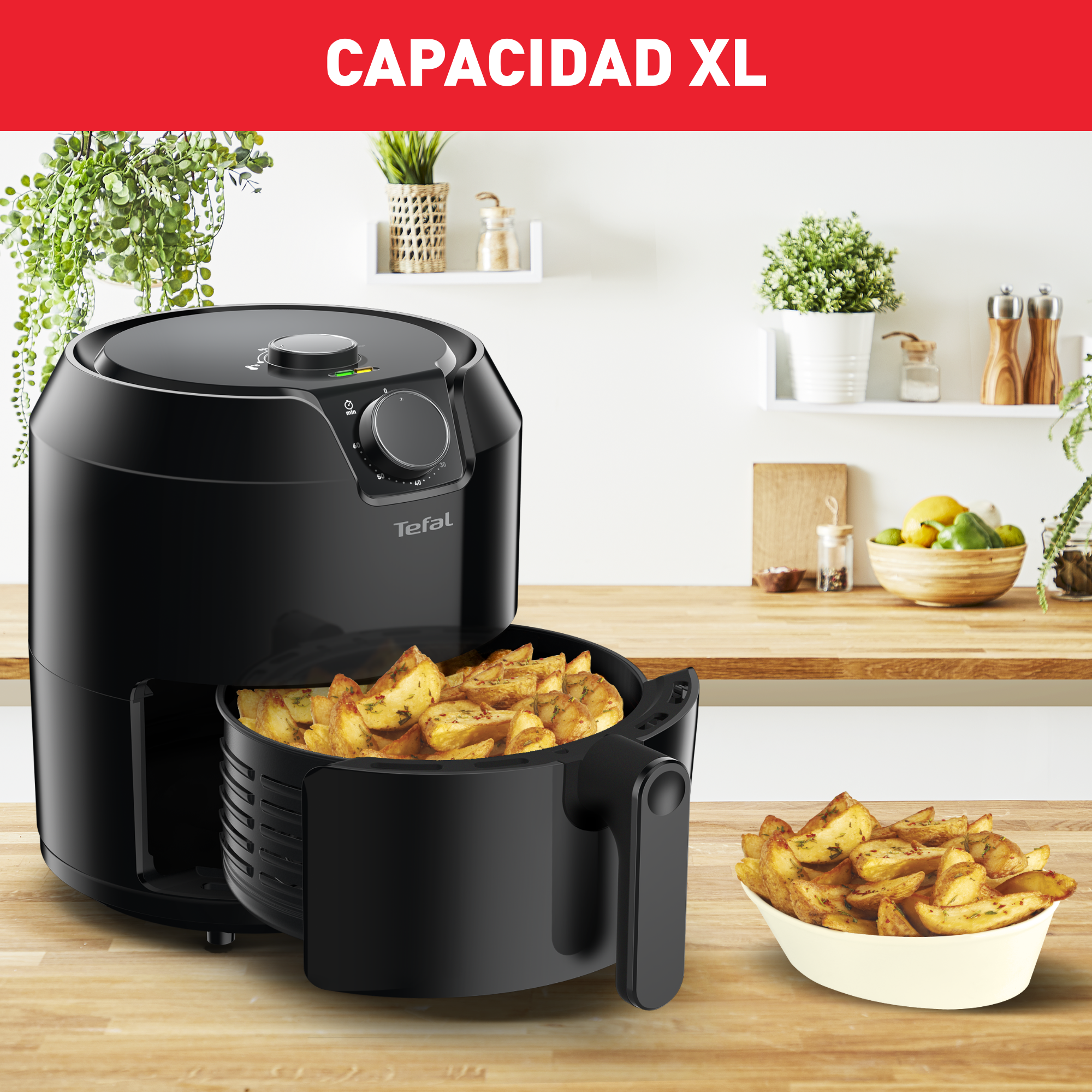 Freidora de aire negra con bandeja de comida y un cuenco de patatas fritas.