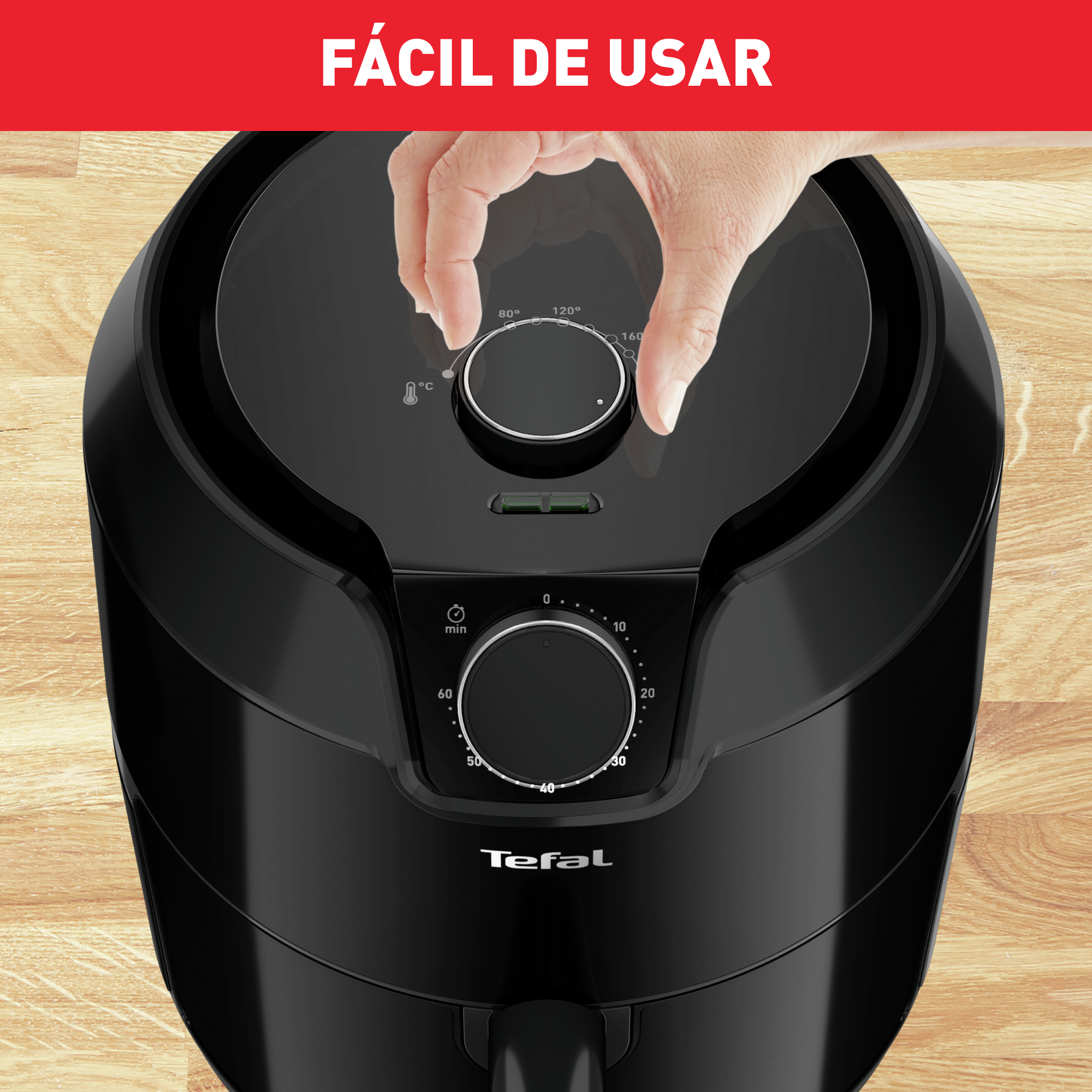 Primer plano de una freidora de aire negra con una mano ajustando el dial.
