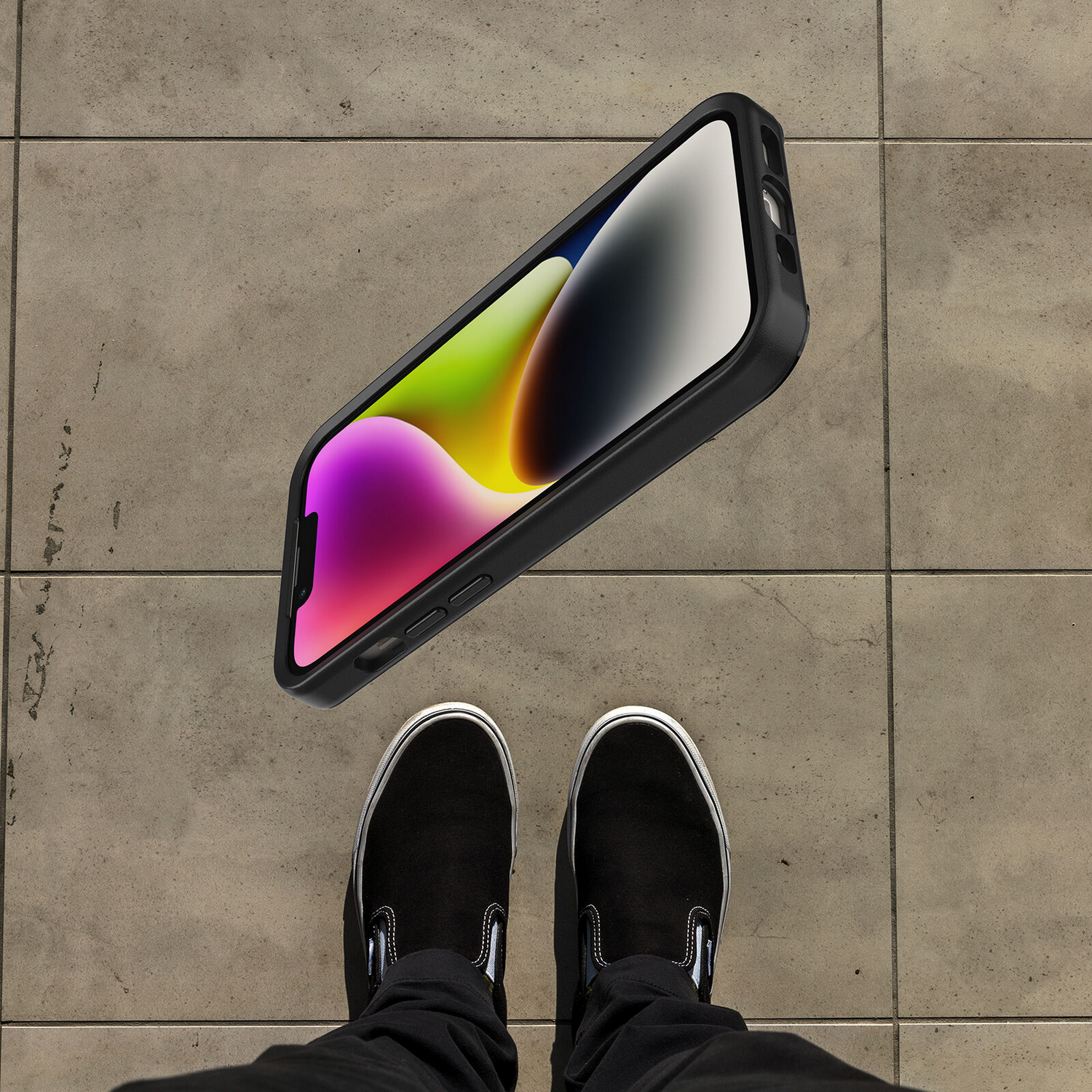 Een persoon staat boven een telefoon. Telefoon zit in een hoesje, scherm omhoog.